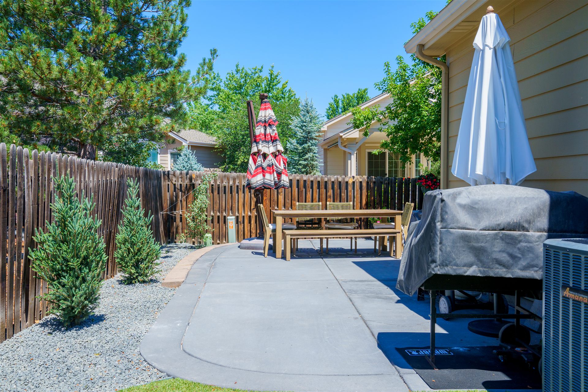 Concrete dining patio at the end of a narrow side yard