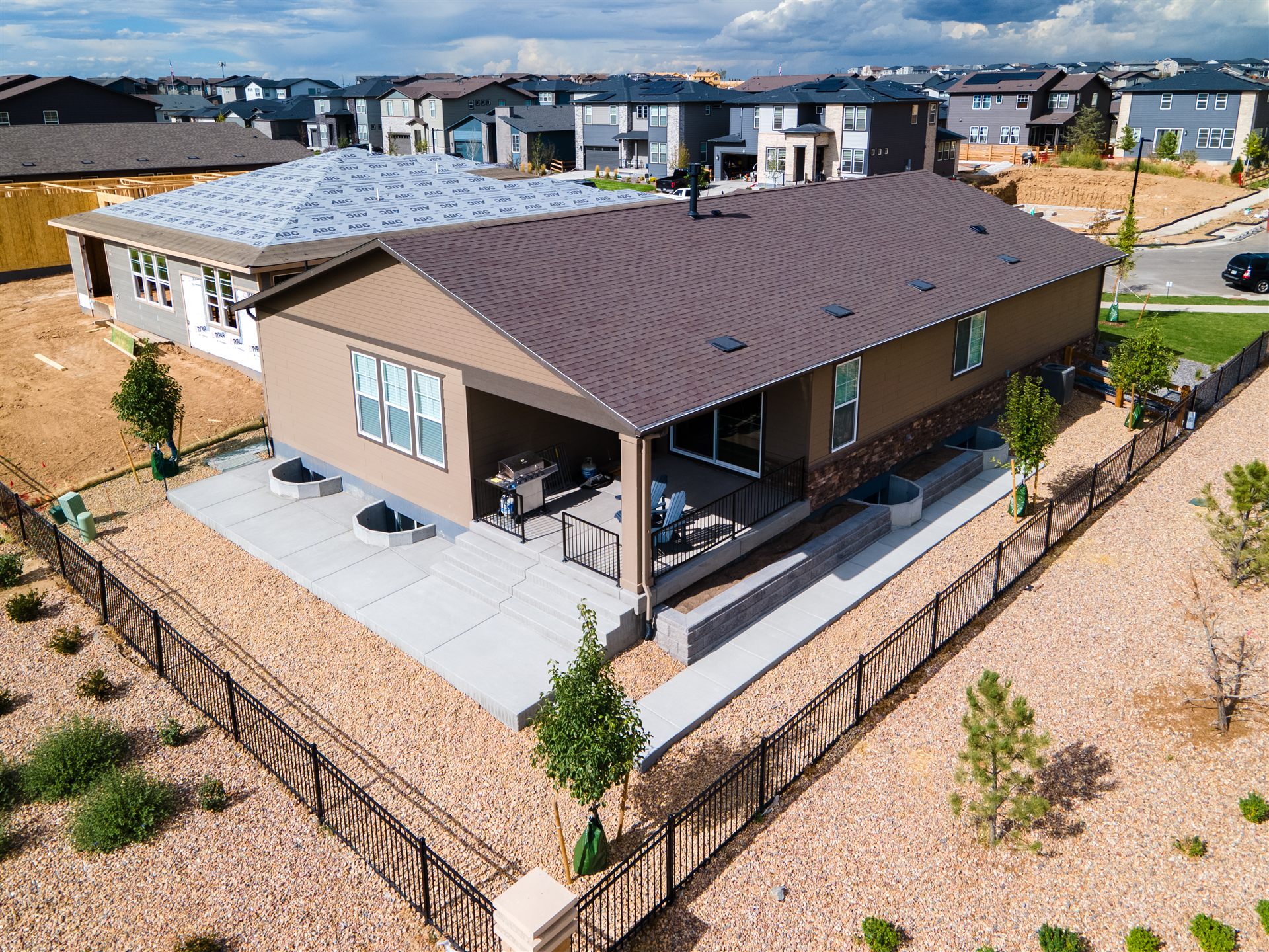 Aerial view of a new Aurora home with a concrete patio and xeriscape