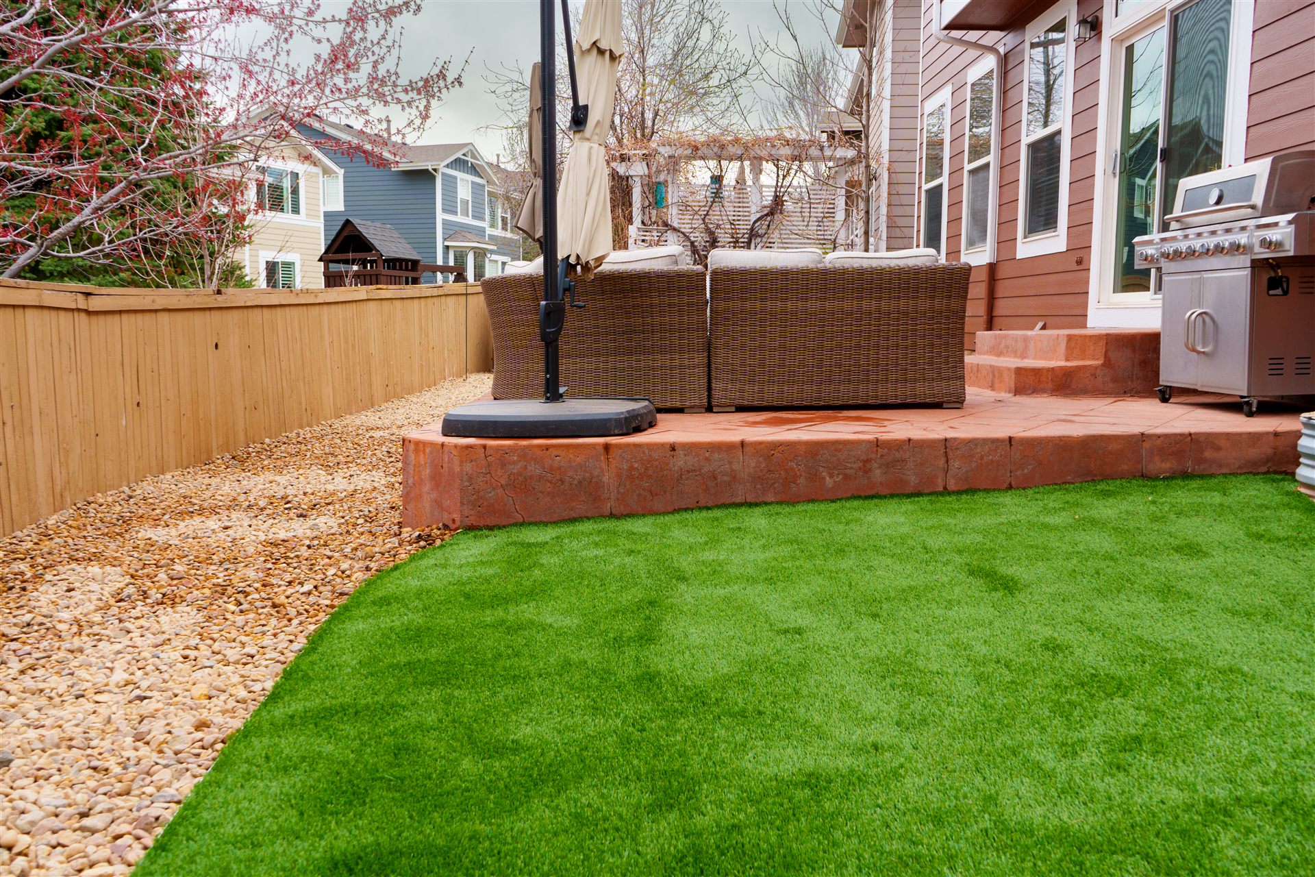 Synthetic turf in front of a raised patio
