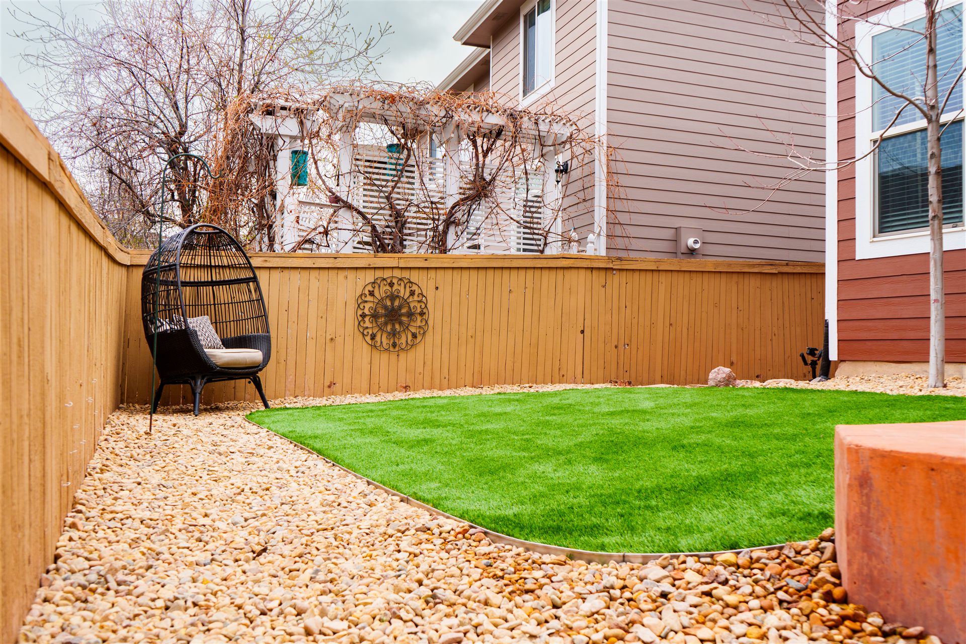 Turf and river rock along a new wood fence