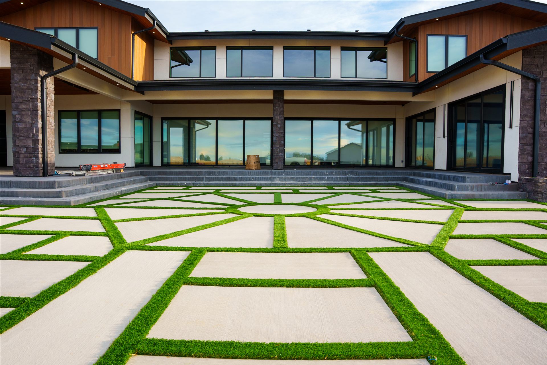 Large concrete slabs with synthetic turf joints behind a modern home in Brighton, CO