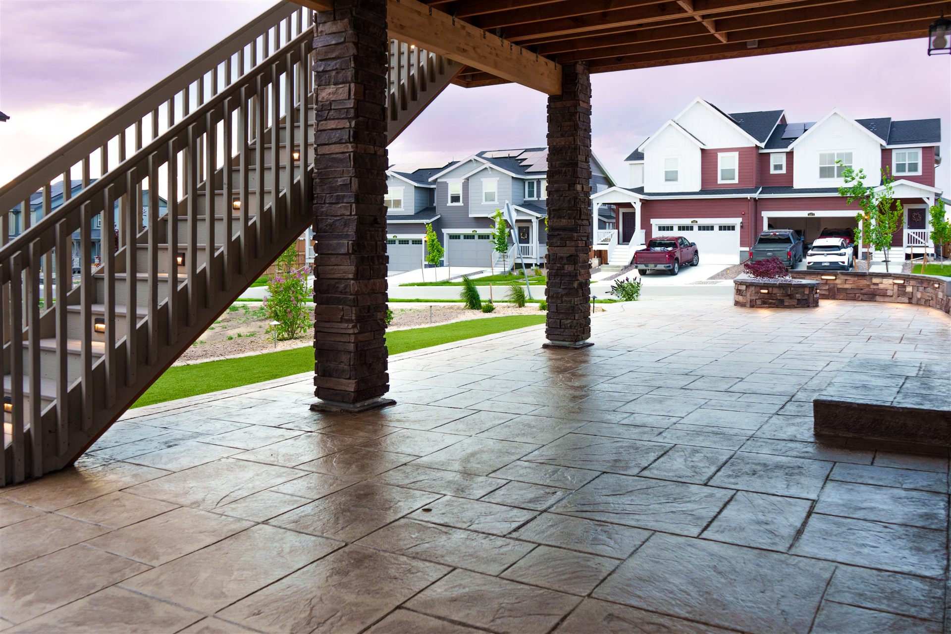 Stamped concrete patio under a deck with stone-wrapped posts