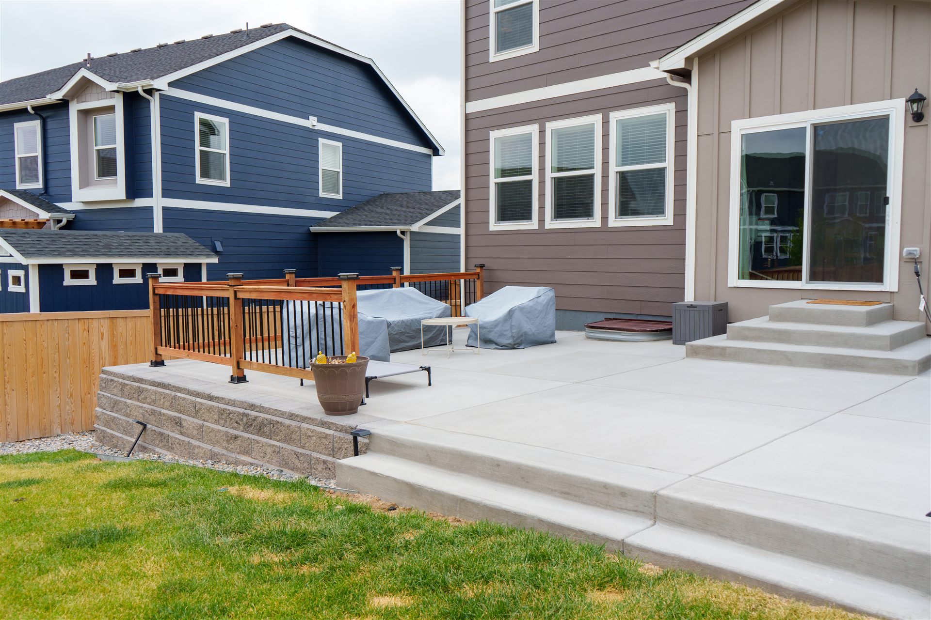 Raised concrete patio on a block retaining wall with a railing in Broomfield