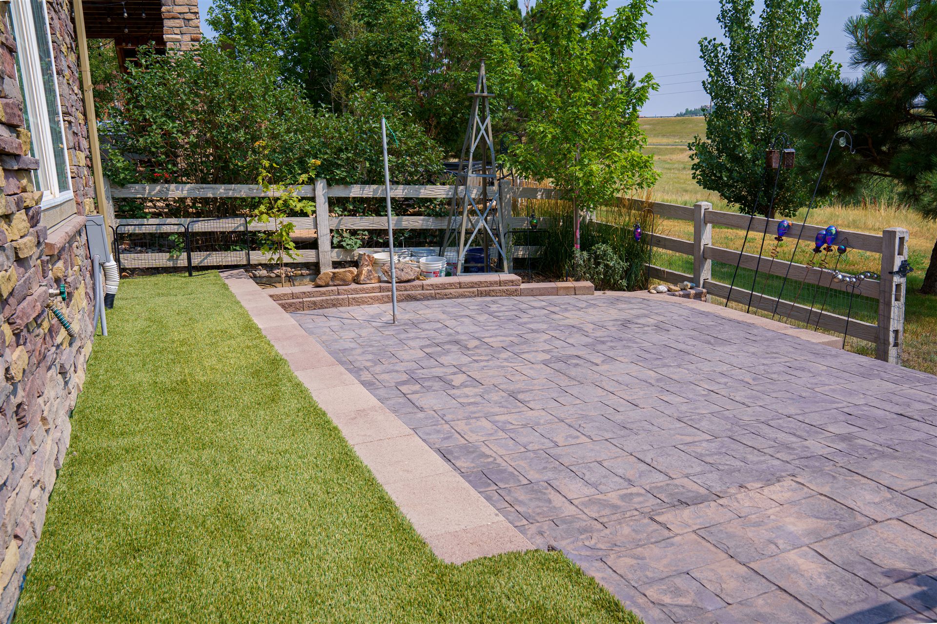 Stamped concrete patio next to a stone veneer home