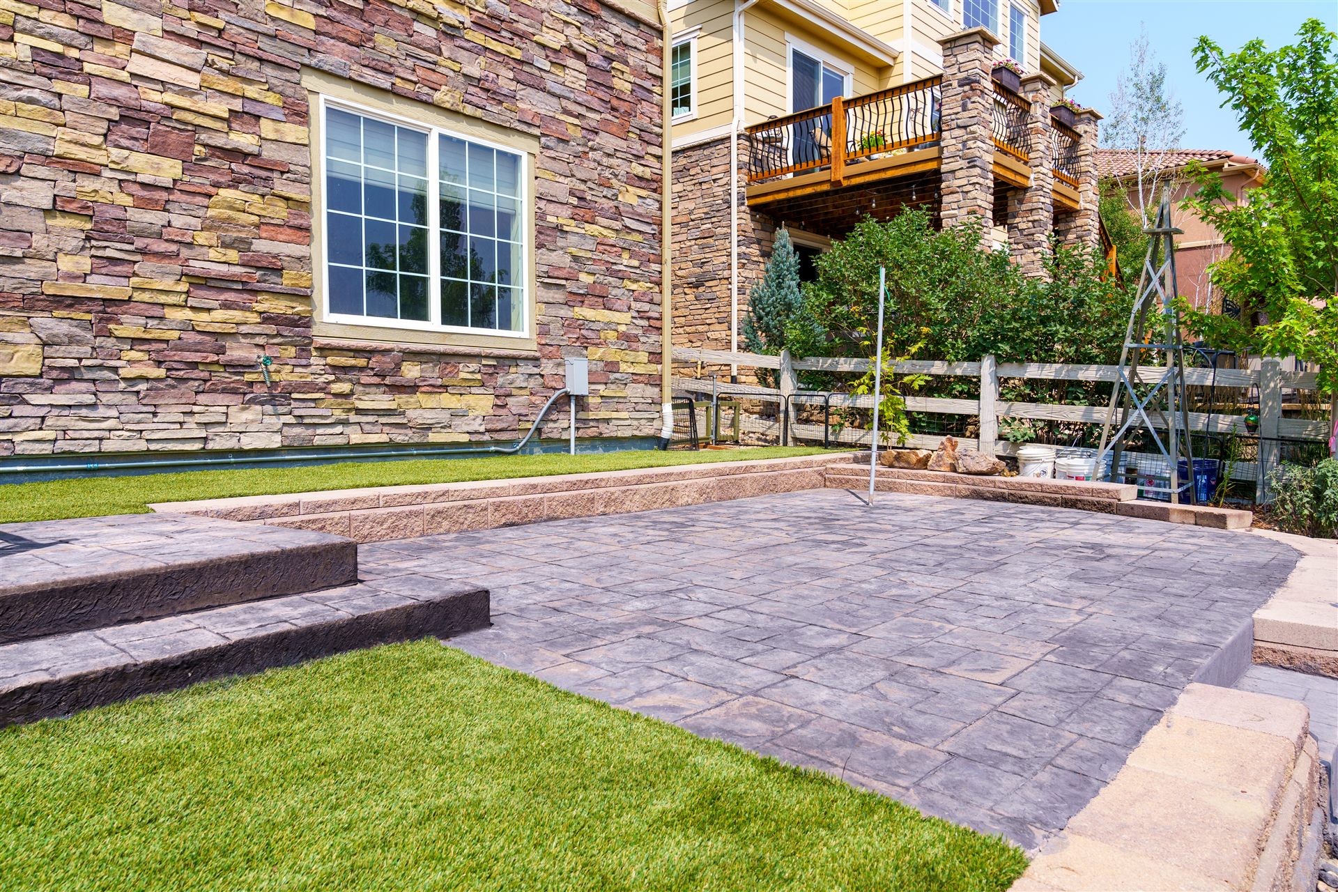 Stamped concrete patio with steps and synthetic turf in Broomfield, CO