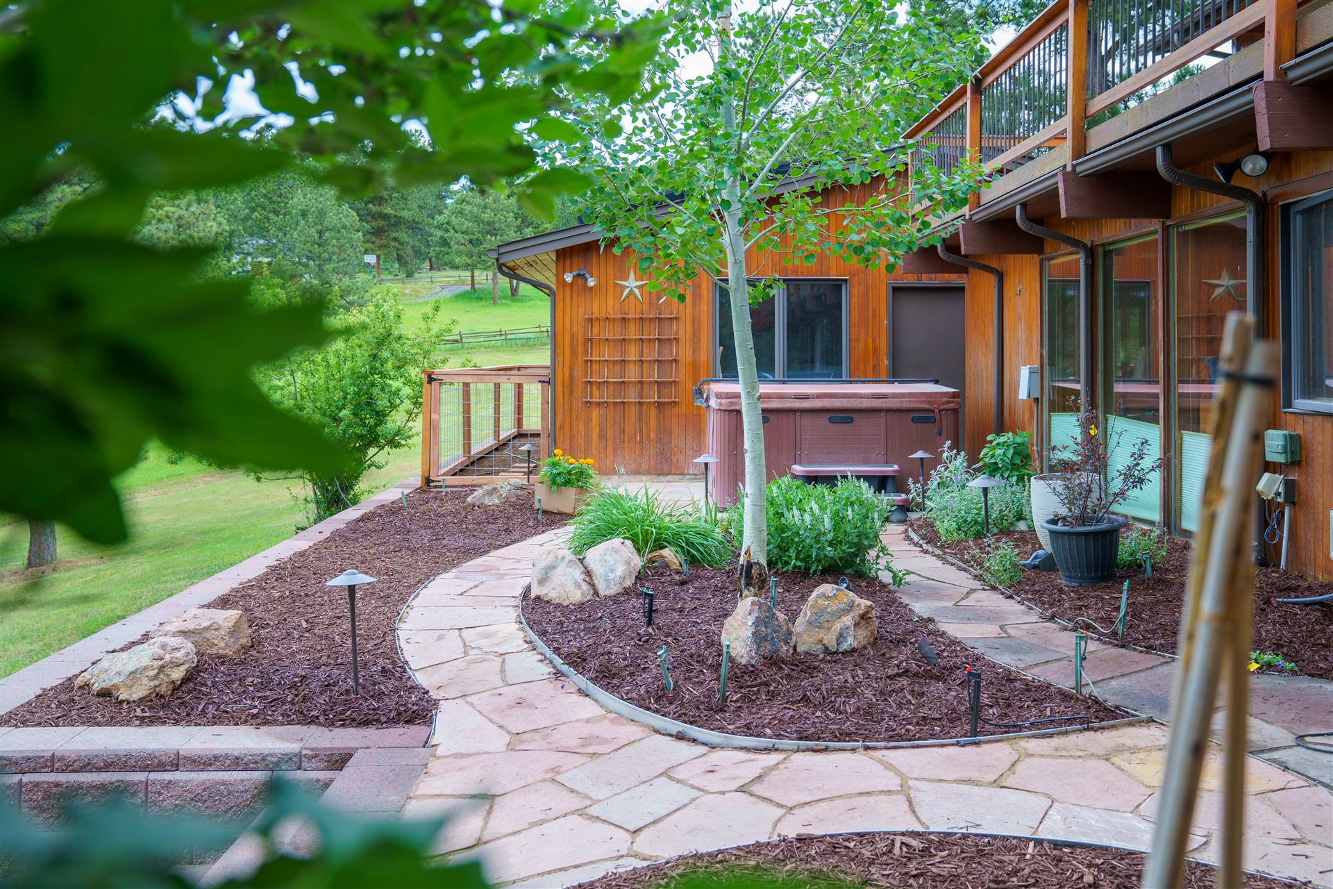 Backyard with flagstone walkways, mulch beds and landscape lighting in Castle Rock, CO