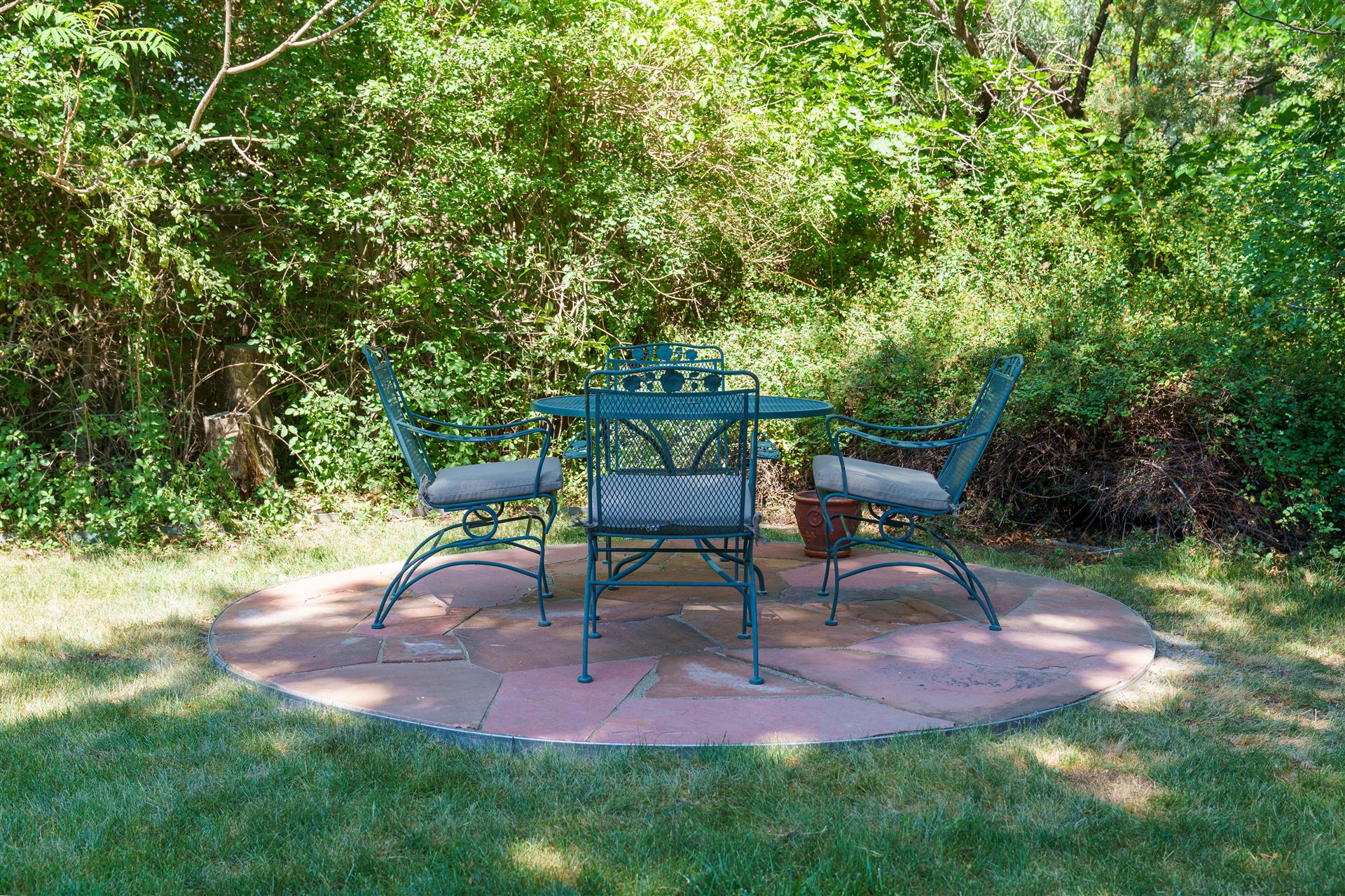 Circular flagstone patio with a dining set in a Castle Rock backyard