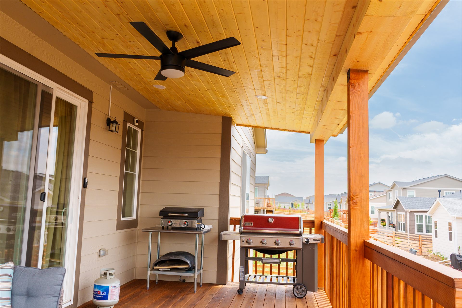 Covered deck with wood ceiling, ceiling fan and grill area