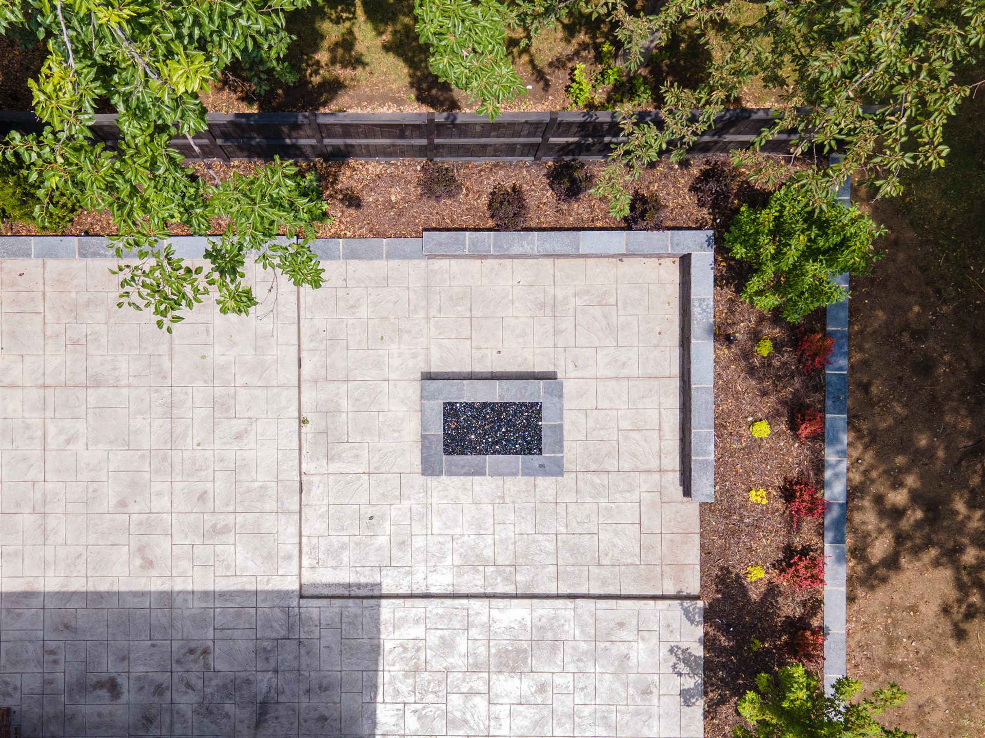 Overhead view of a stamped concrete patio with a fire pit
