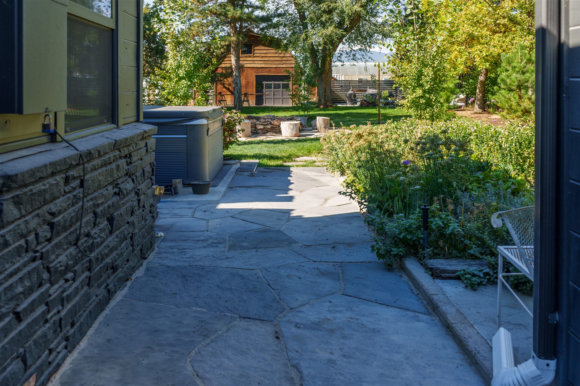 Flagstone side-yard walkway next to a stone veneer wall