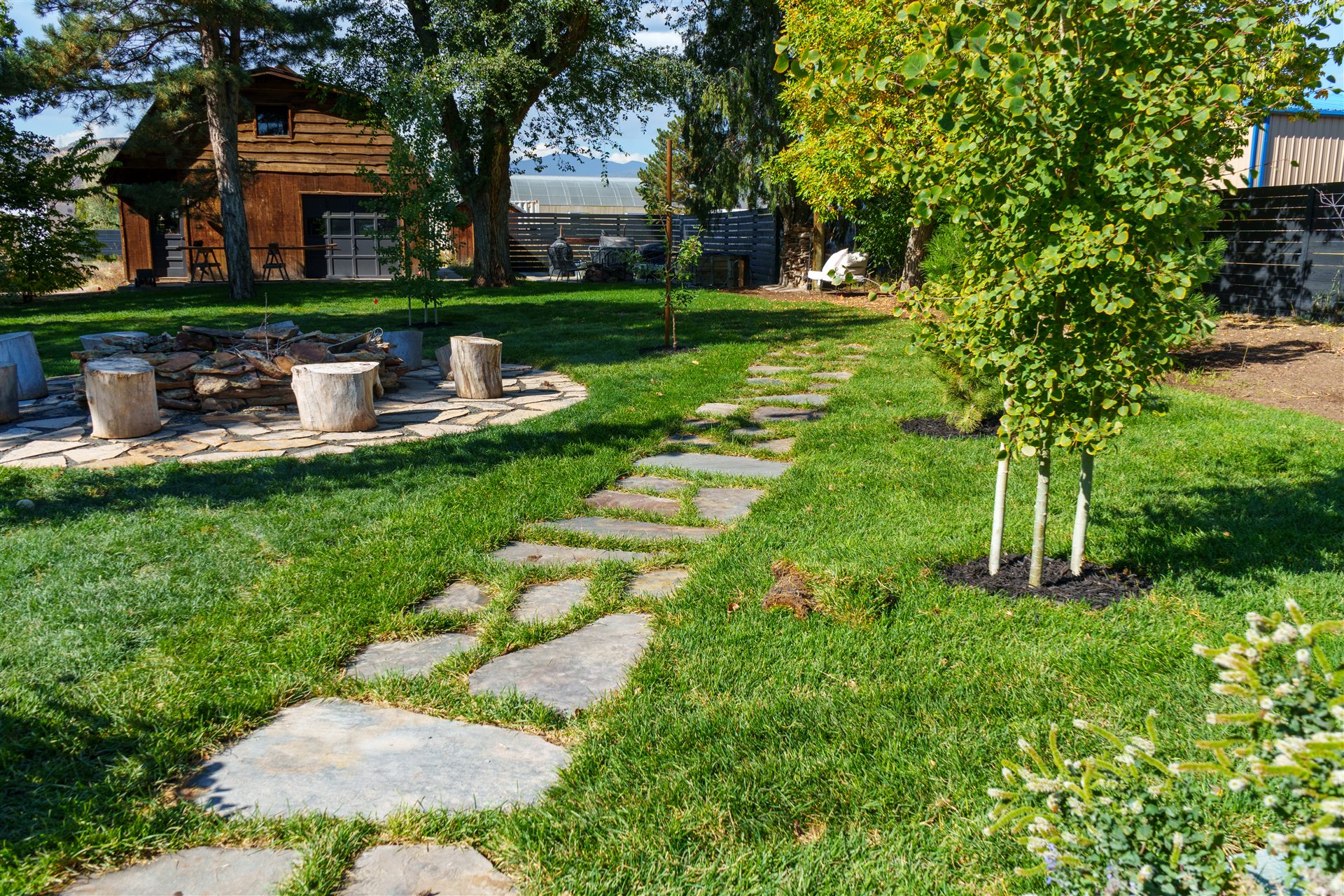 Flagstone stepping-stone path through a lawn to a fire pit area in Castle Rock
