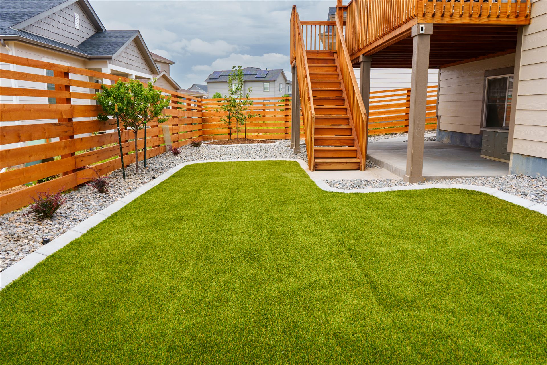 New sod lawn below an elevated deck with a horizontal wood fence