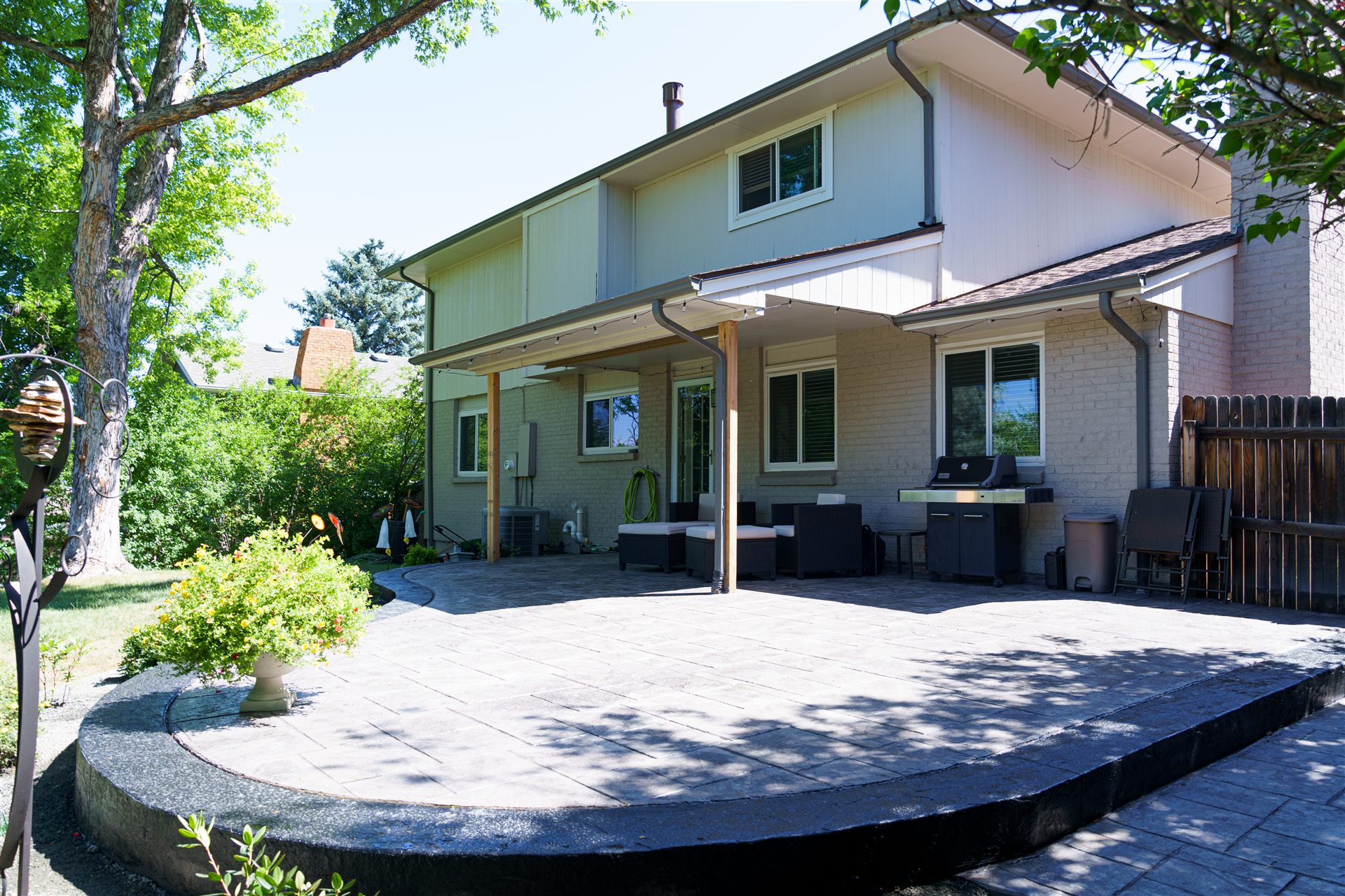 Stamped concrete patio with a contrasting border behind a two-story home
