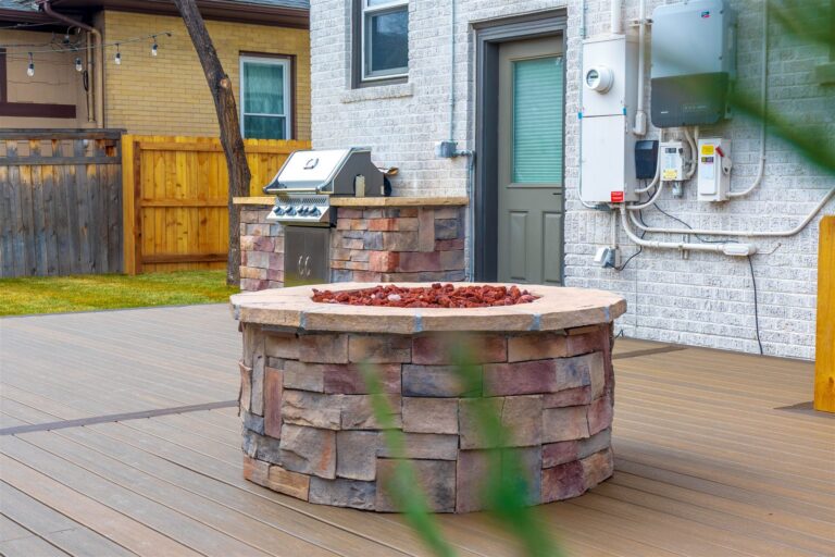 Stone fire pit with a matching grill island in Centennial, CO