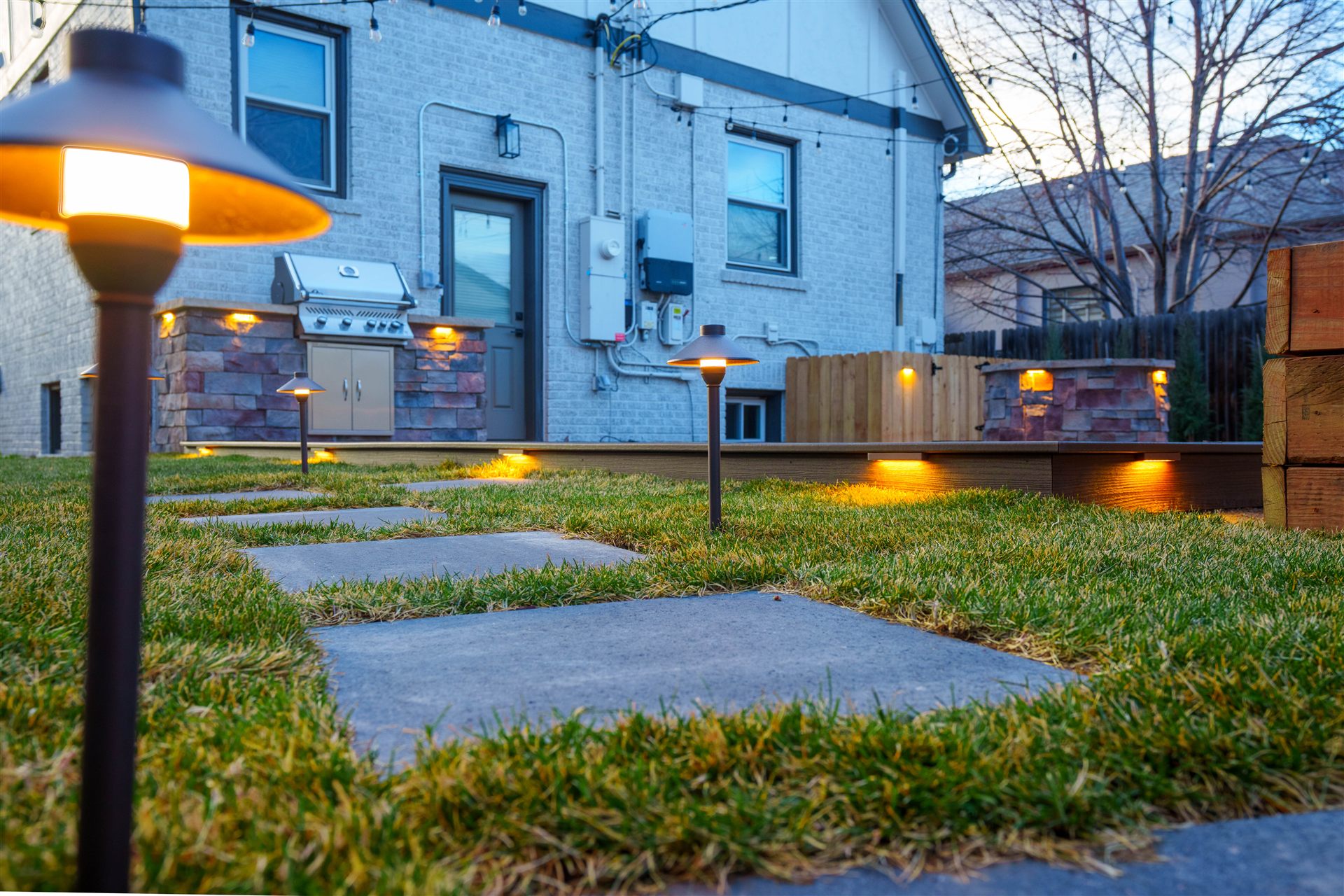 Path lights along stepping stones leading to a composite deck