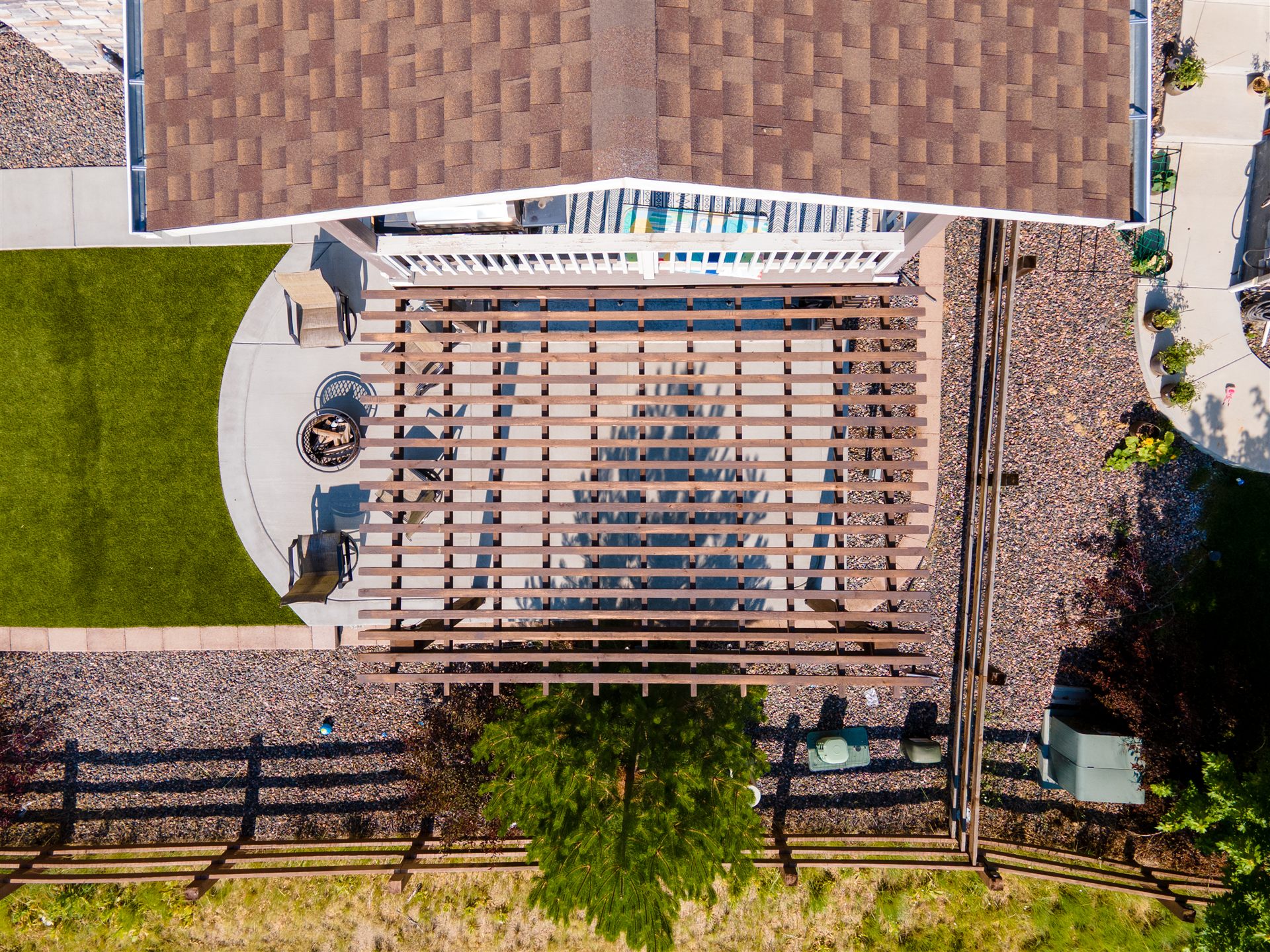 Aerial view of a pergola, curved concrete patio and synthetic turf