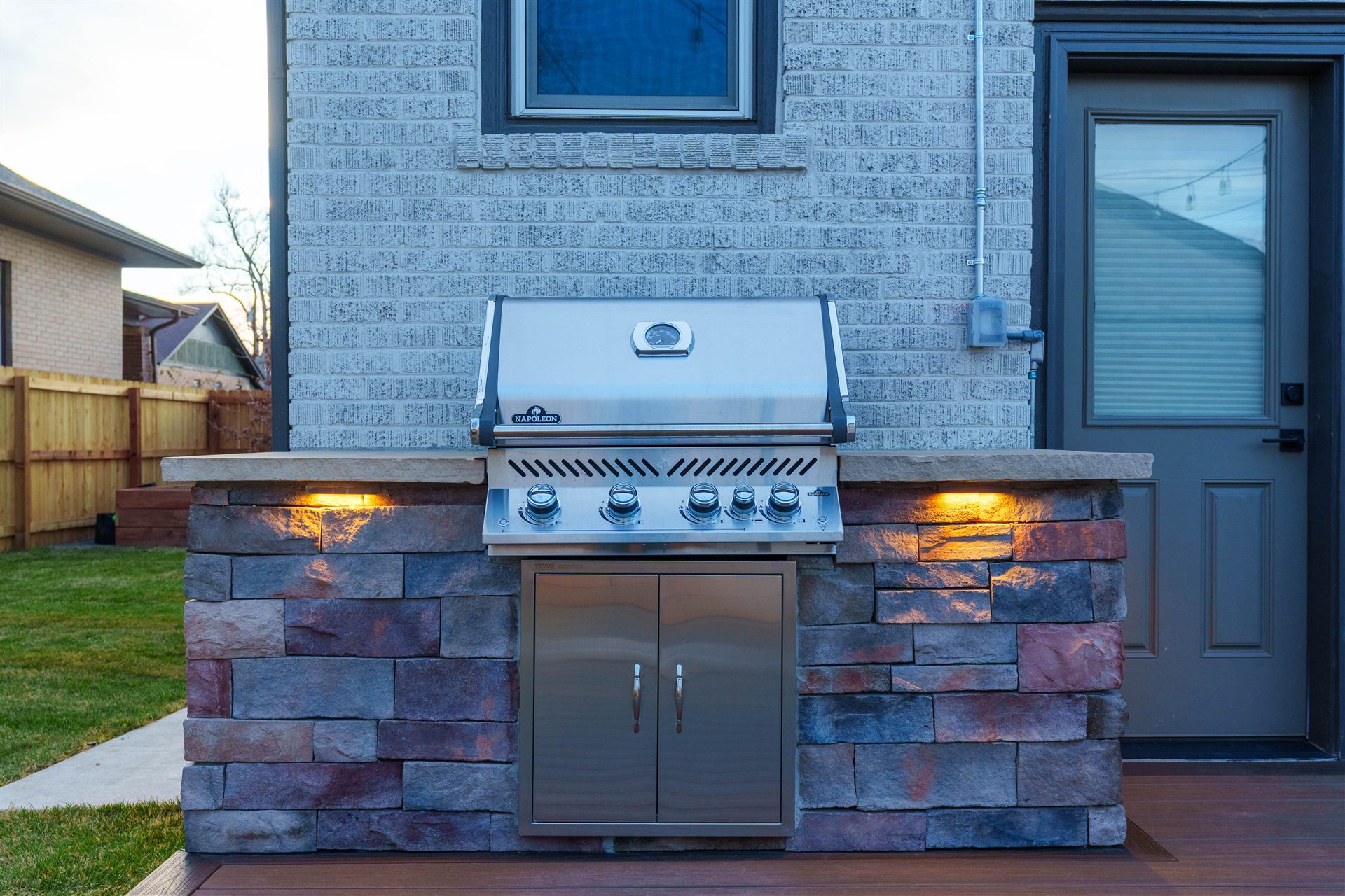 Stone grill island with a built-in grill and accent lighting
