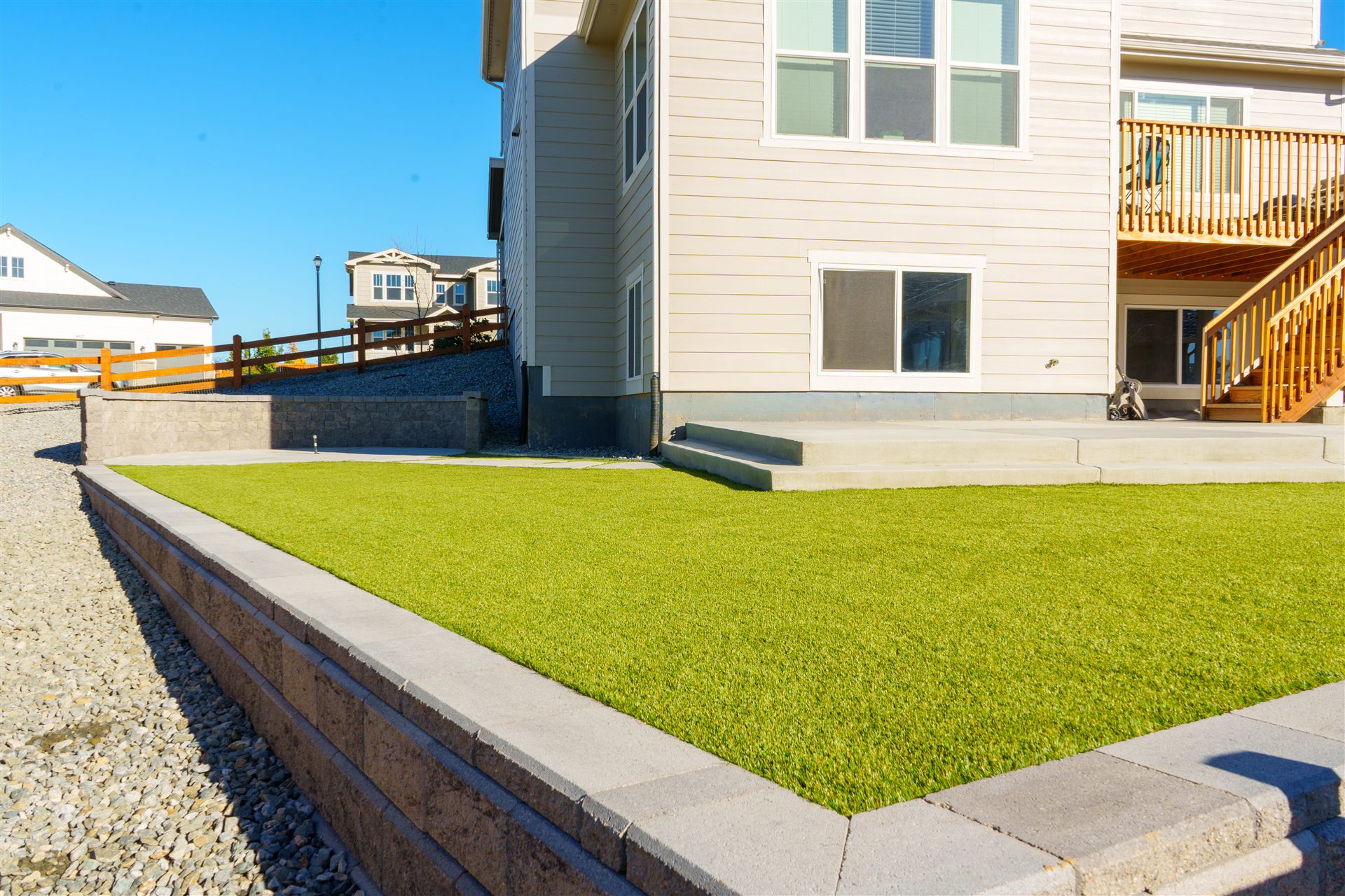 Synthetic turf framed by a capped block wall and concrete steps