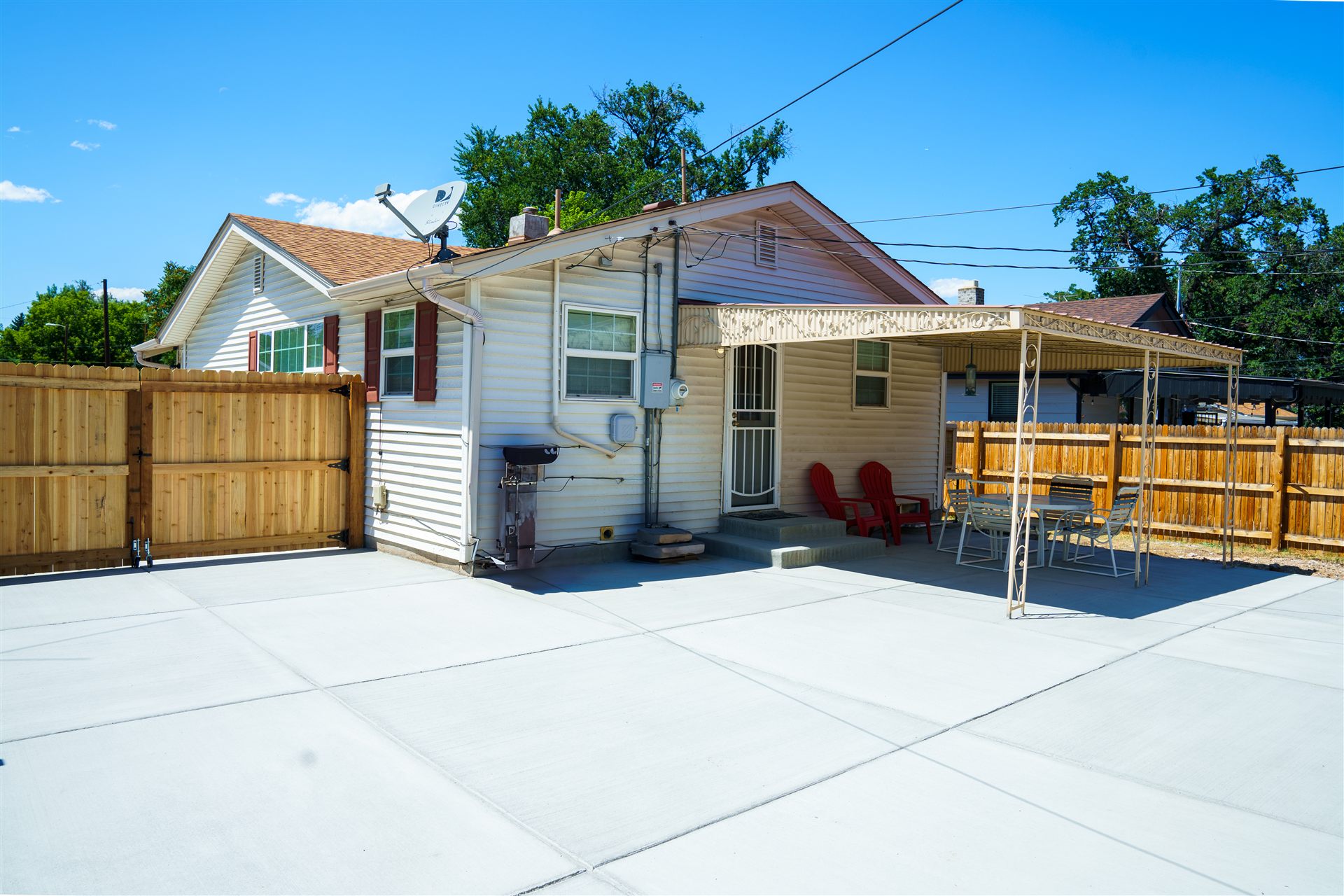 Large concrete pad behind a home with a patio area