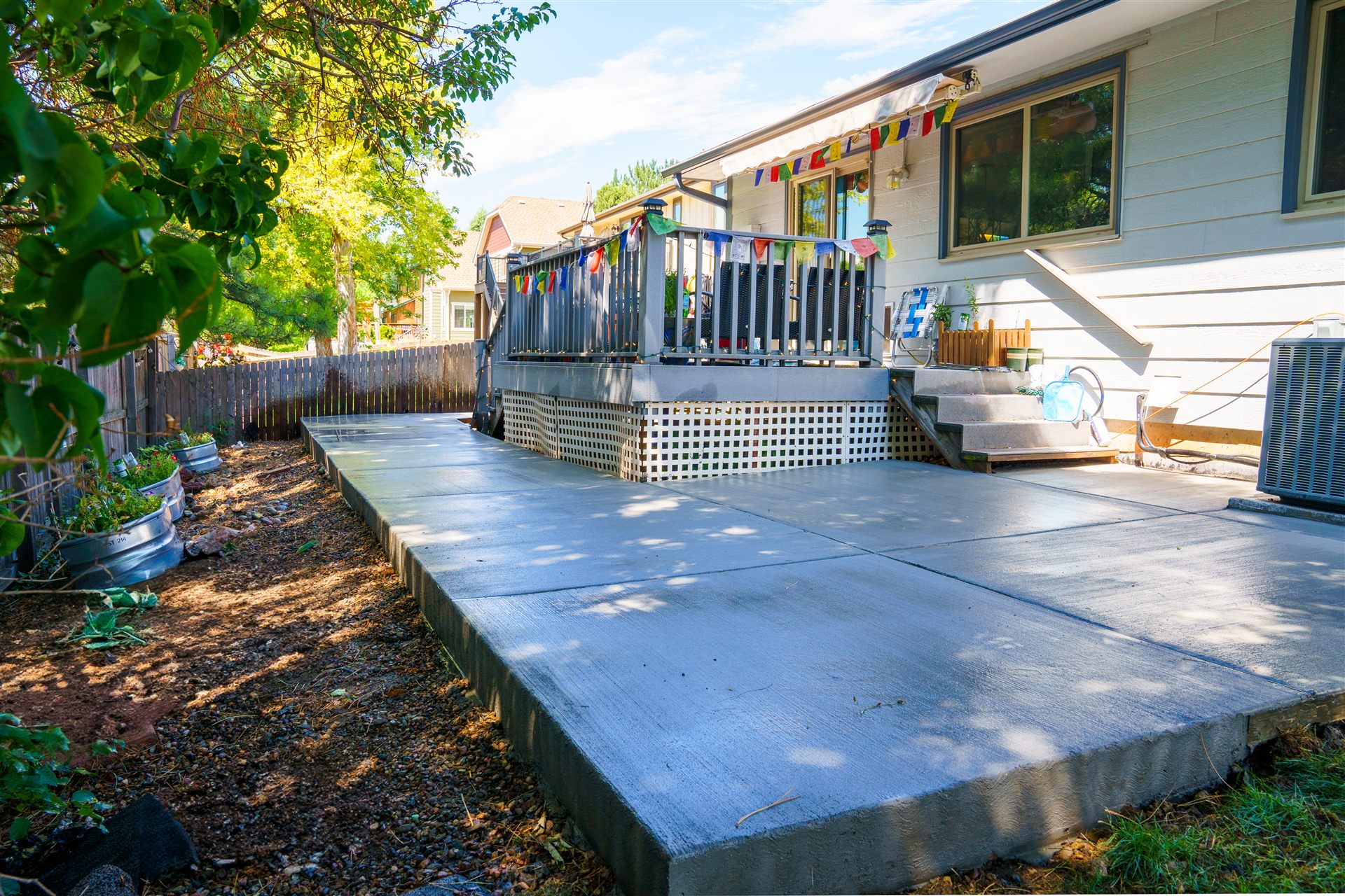 Concrete patio next to a raised deck