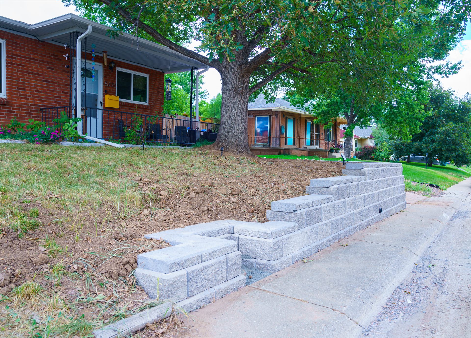 Block retaining wall stepping down at the corner of a front yard