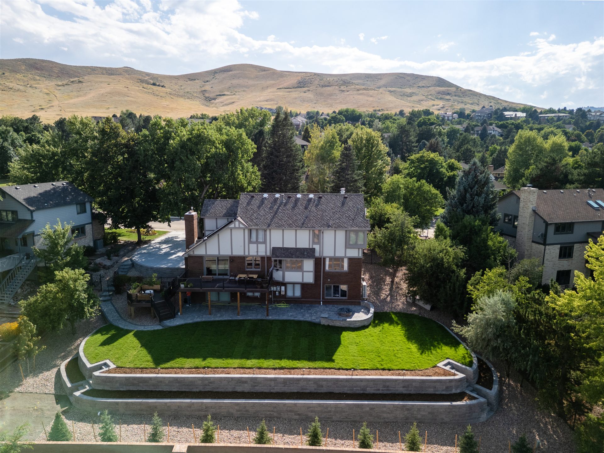 Long curved retaining wall and new sod lawn below the foothills in Lakewood, CO