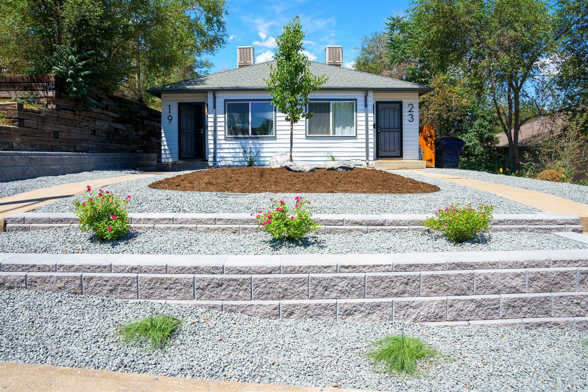 Terraced front yard with rock, grasses and a mulch bed