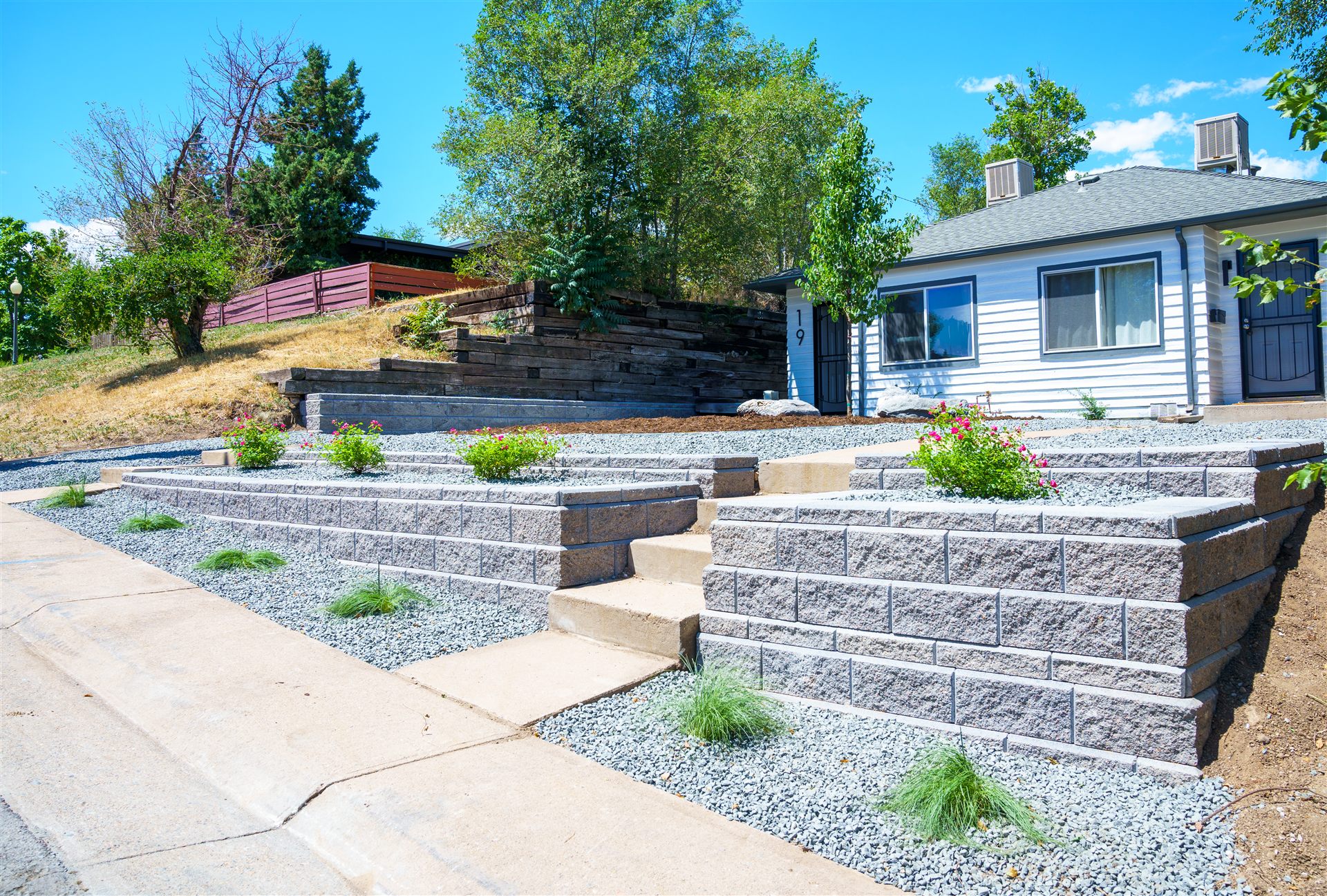 Block retaining walls and concrete steps up a sloped front yard