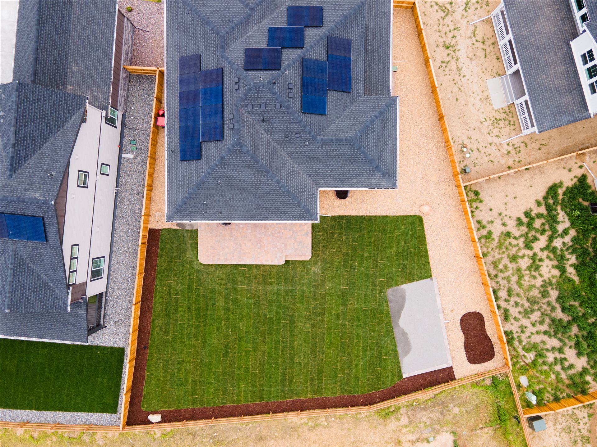 Overhead view of backyard sod, patio and rock borders