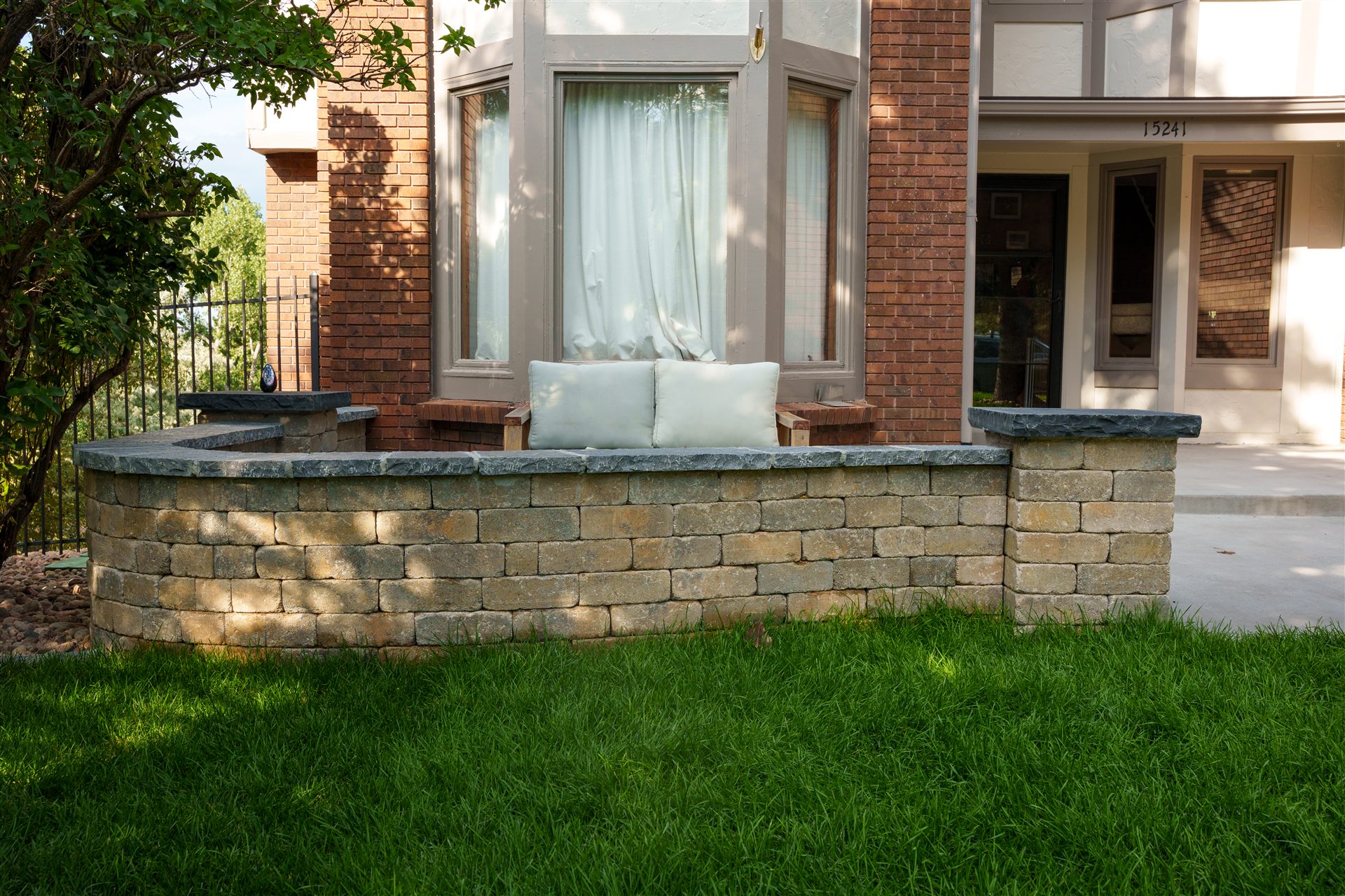Block seat wall with a stone cap at the front entry