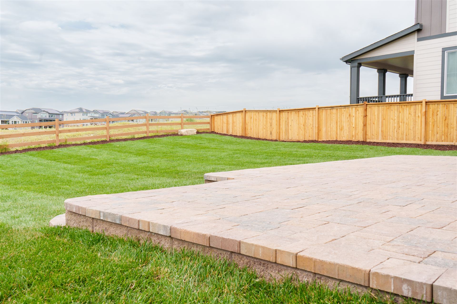 Paver patio and lawn along a new wood fence