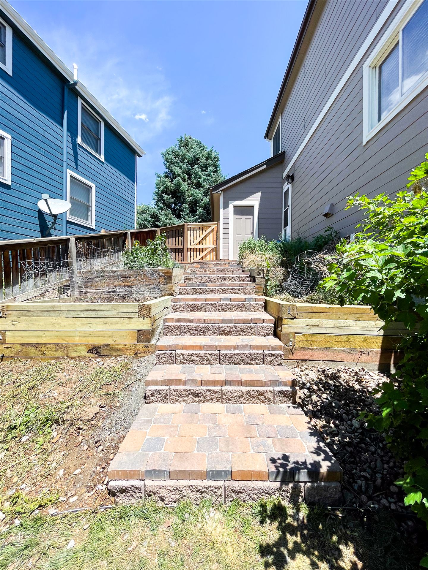 Paver steps climbing through timber-edged terraces