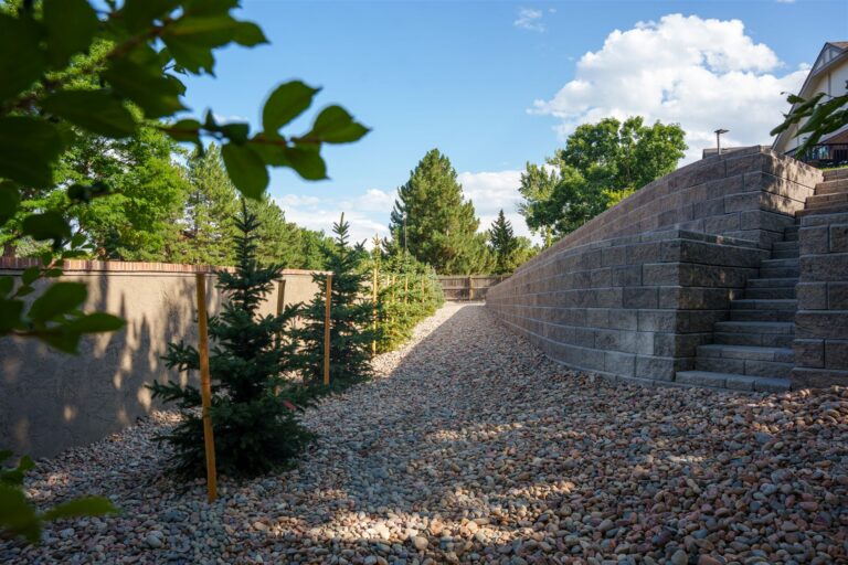 Tiered block retaining walls and stairs with evergreens in Littleton, CO