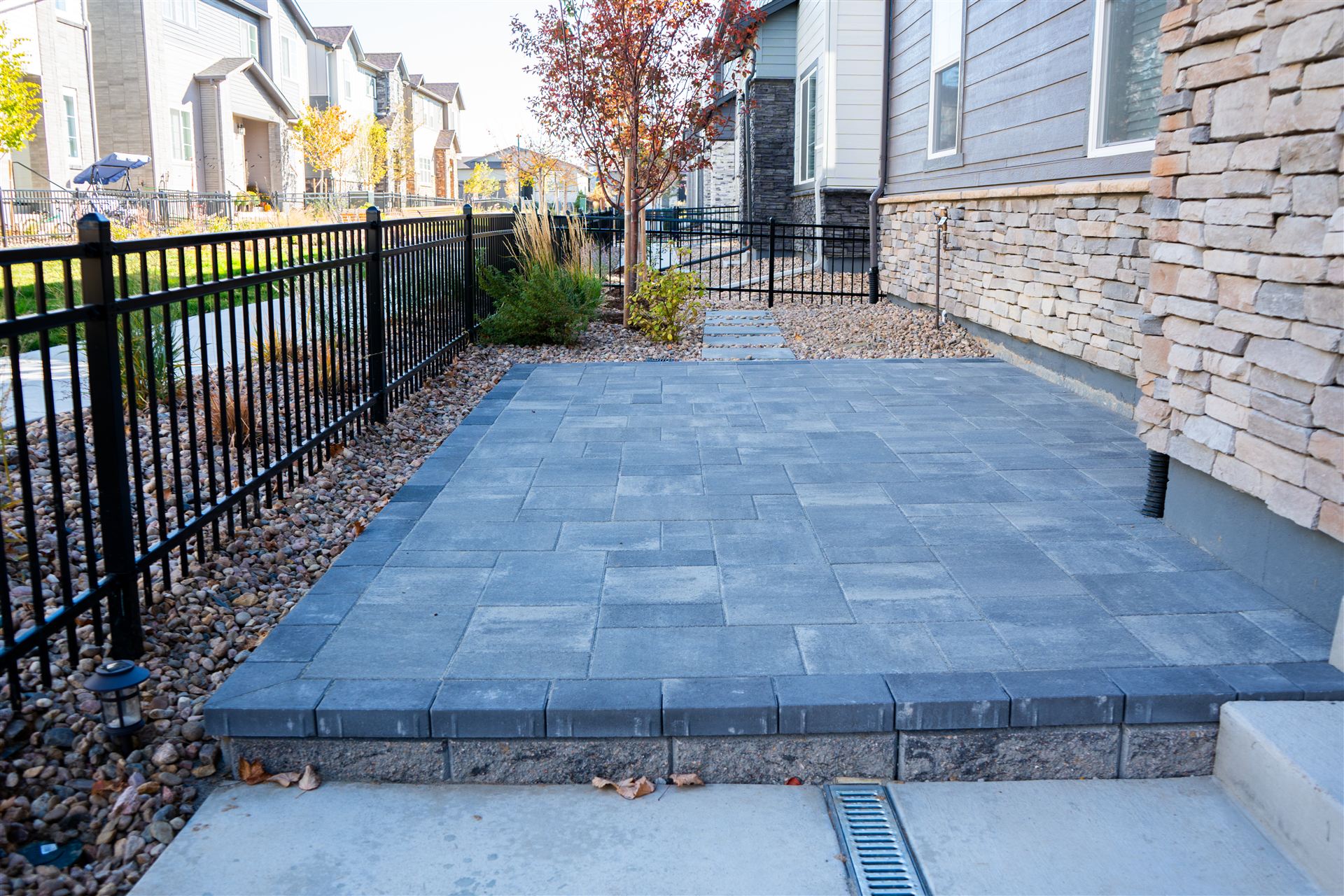 Small side-yard paver patio with a step and rock beds in Littleton, CO