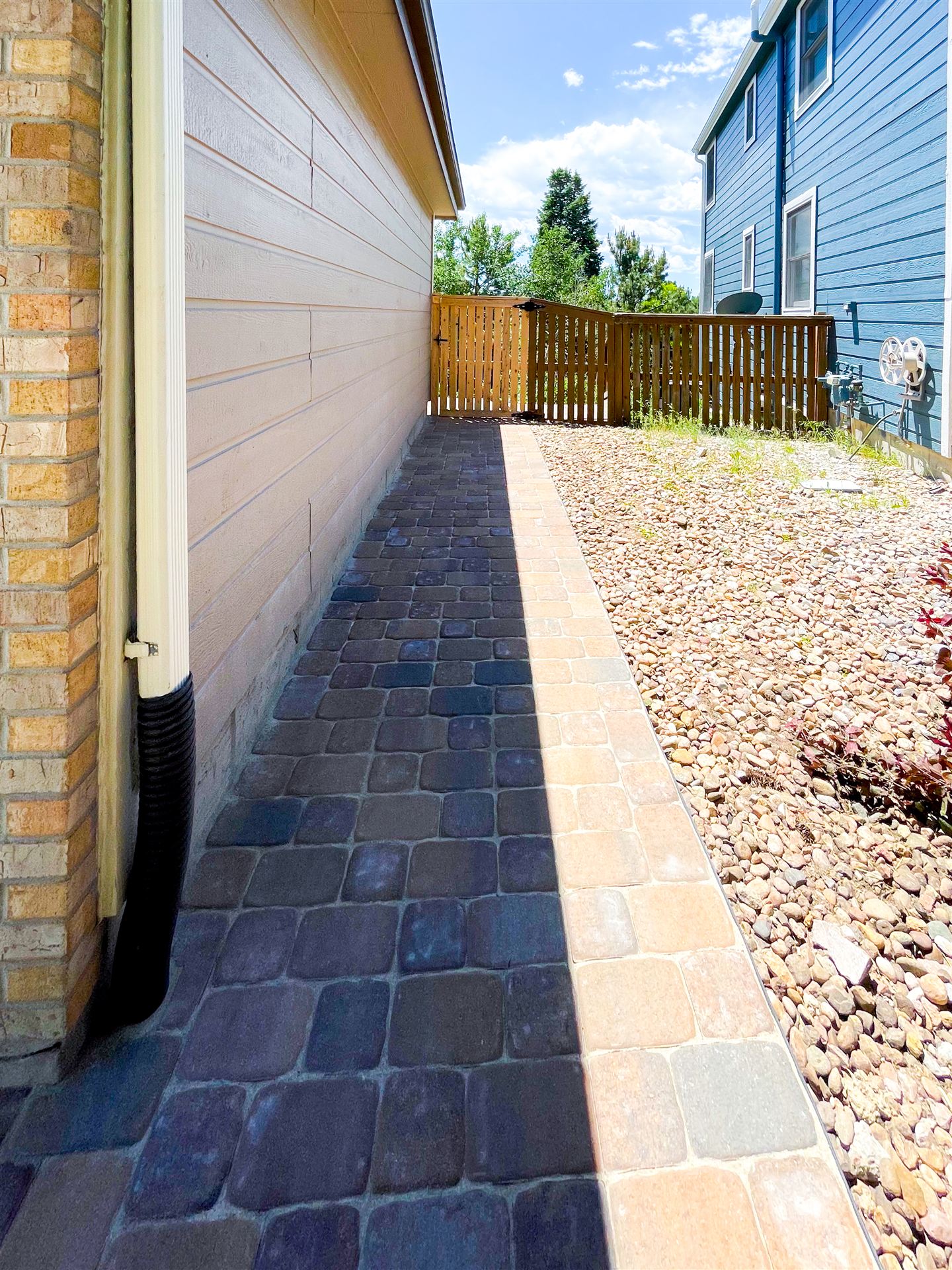 Narrow side-yard paver walkway next to a house