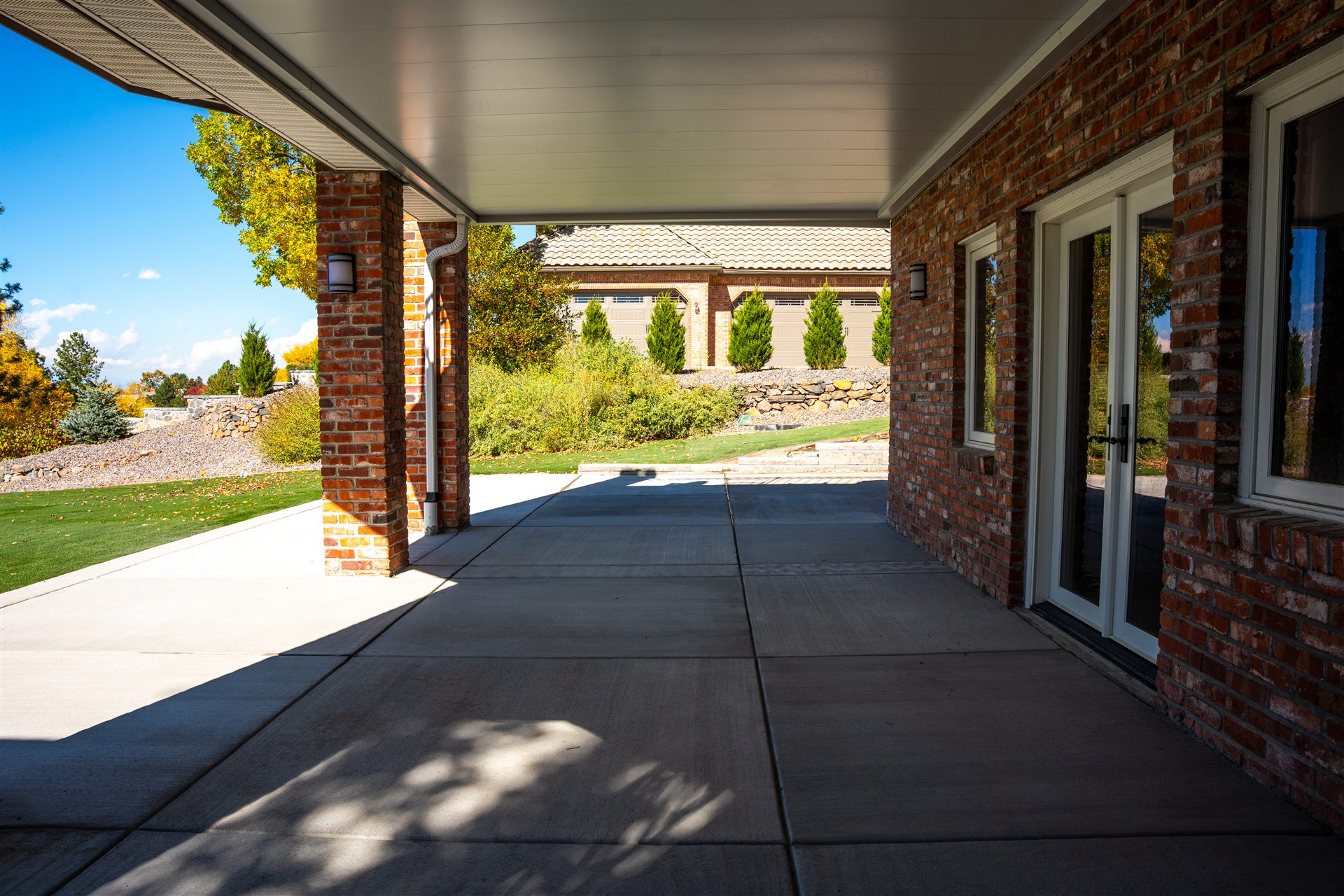 New concrete patio at a walkout basement with French doors