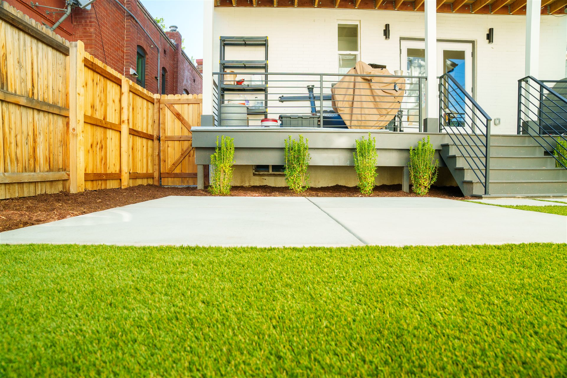 Concrete pad edged by synthetic turf