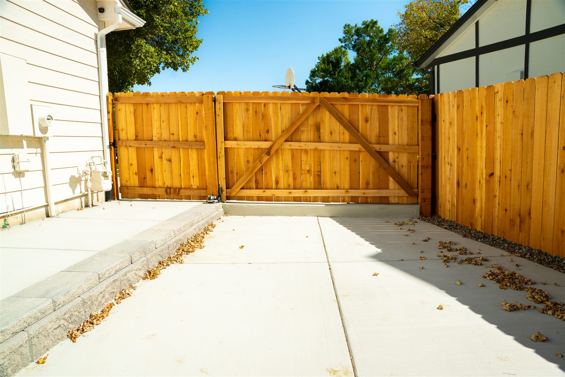 Concrete patio leading to a wide wood gate
