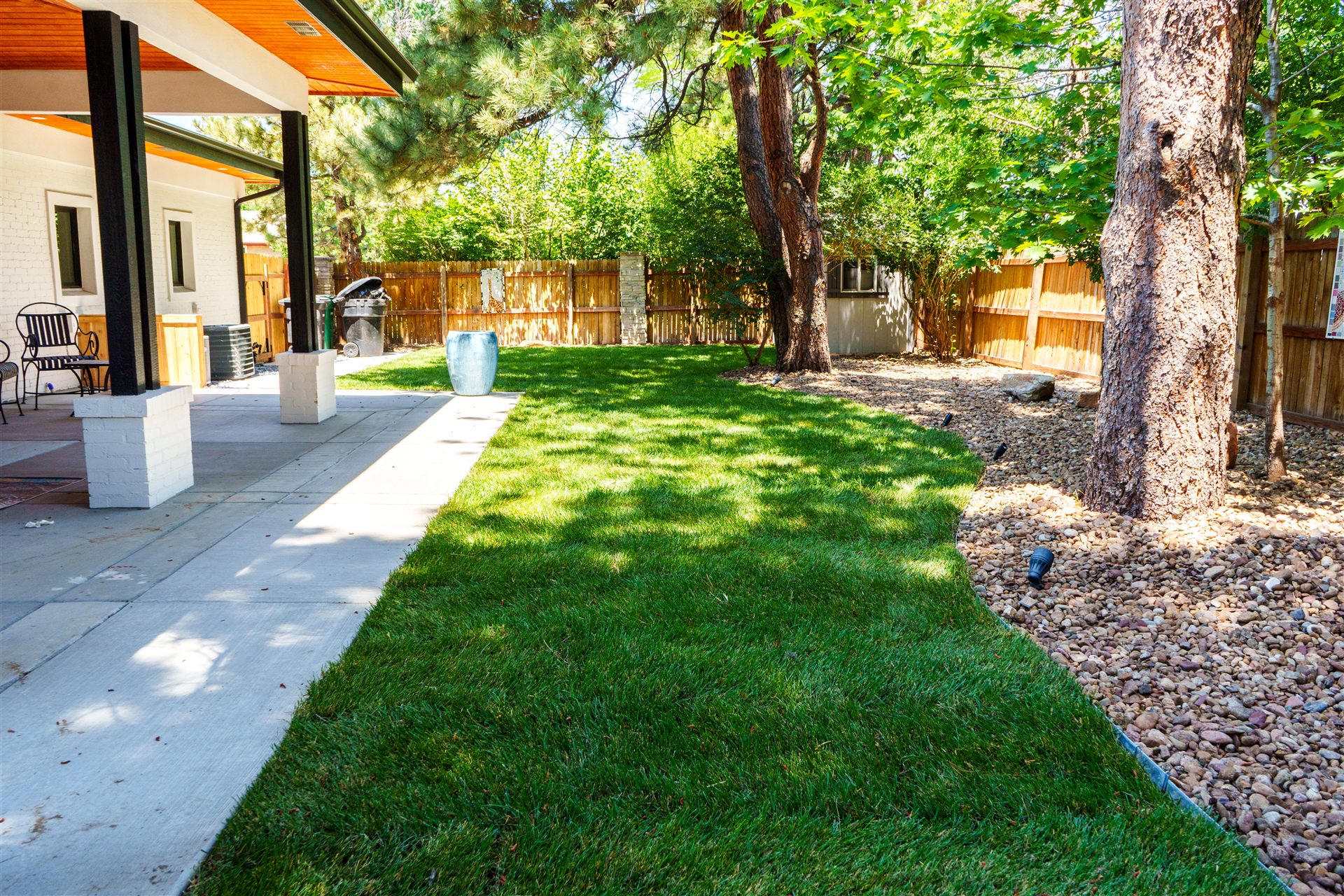 Concrete walkway between the covered patio and new lawn