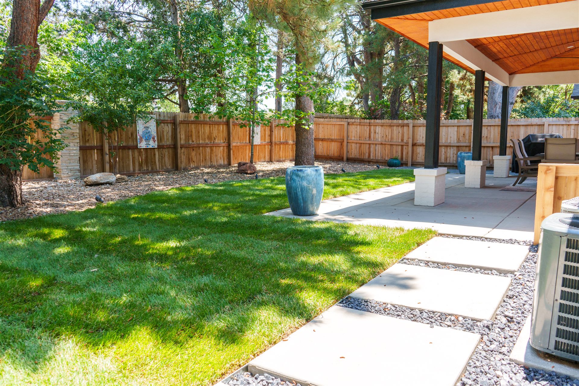 New sod lawn with concrete stepping pads beside a covered patio in Longmont