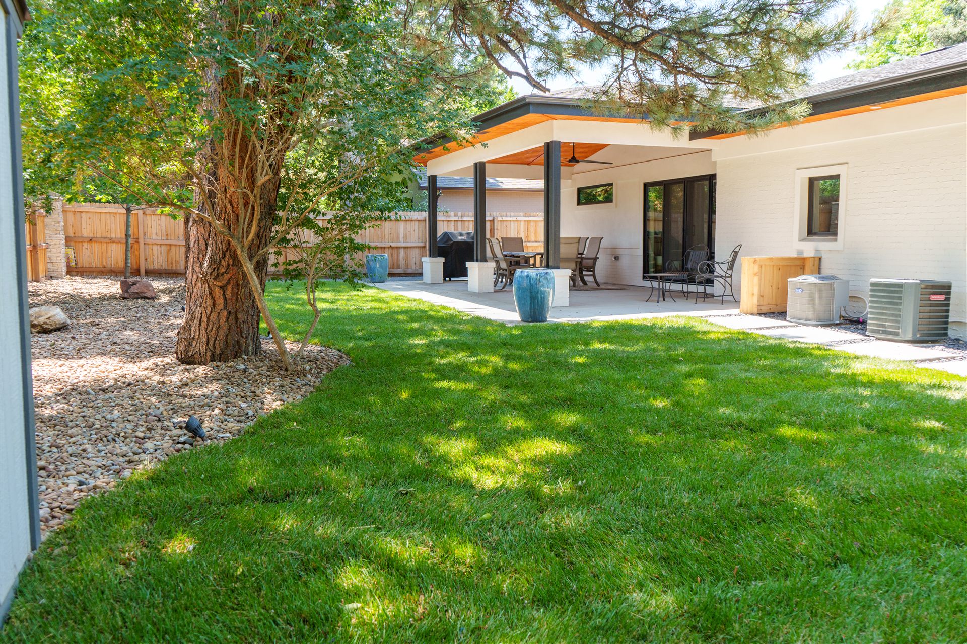 Fresh sod lawn and river rock beds behind a modern ranch