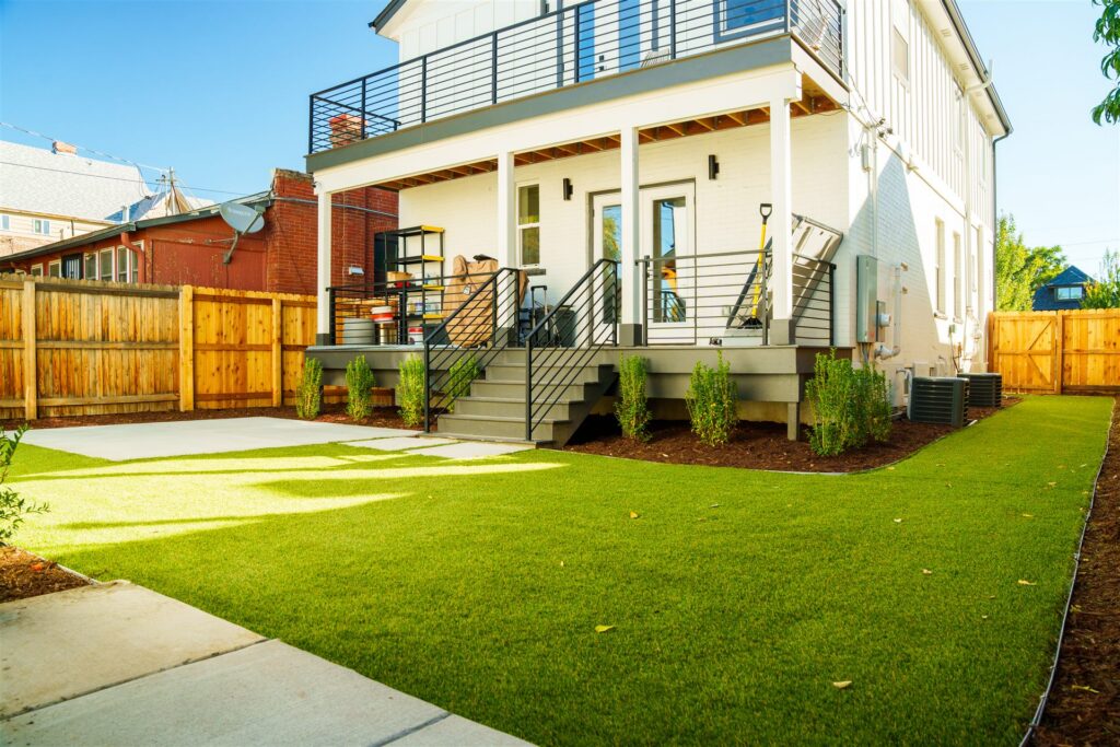 Synthetic turf backyard with a concrete pad behind a home in Longmont, CO