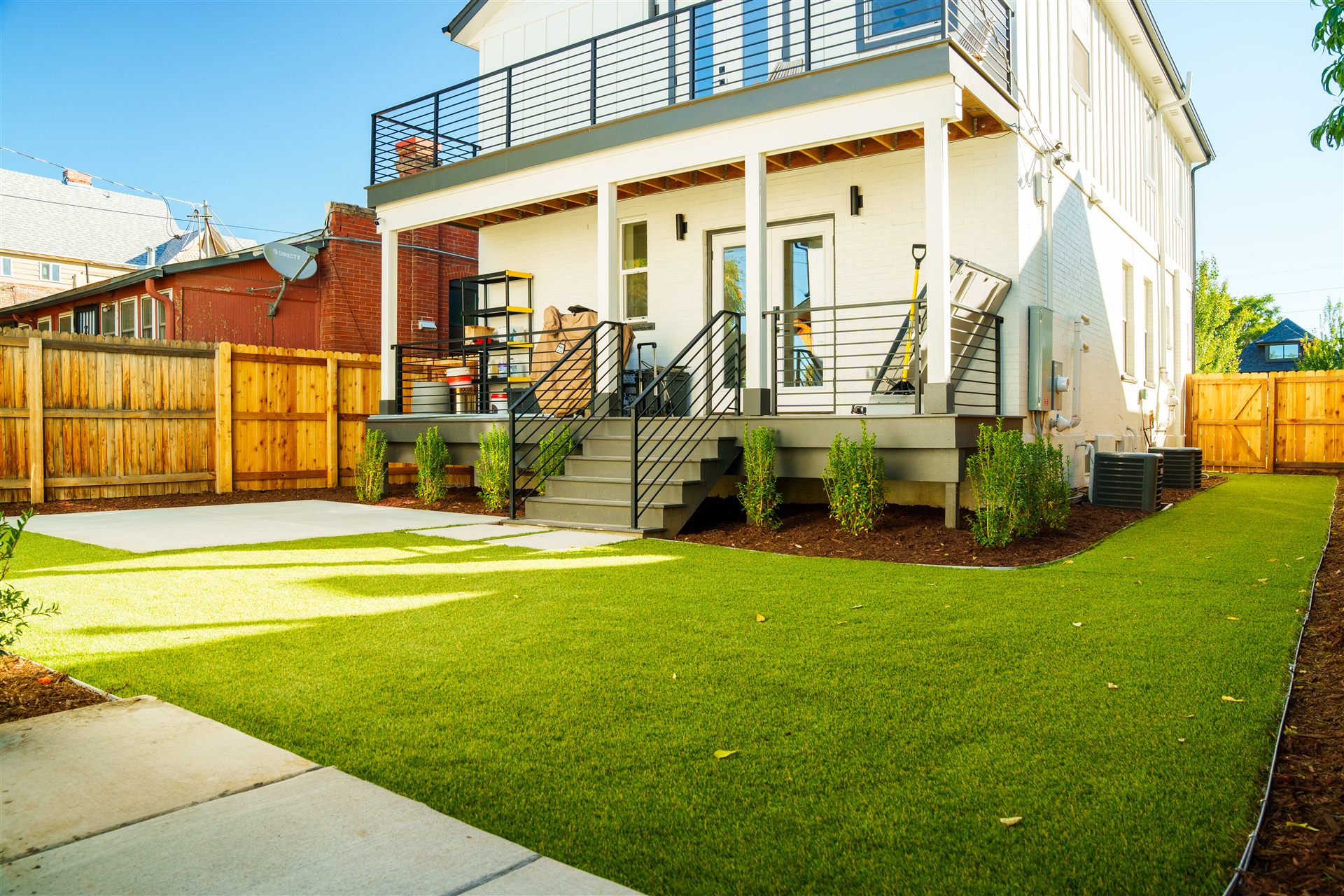 Synthetic turf backyard with a concrete pad behind a home in Longmont, CO