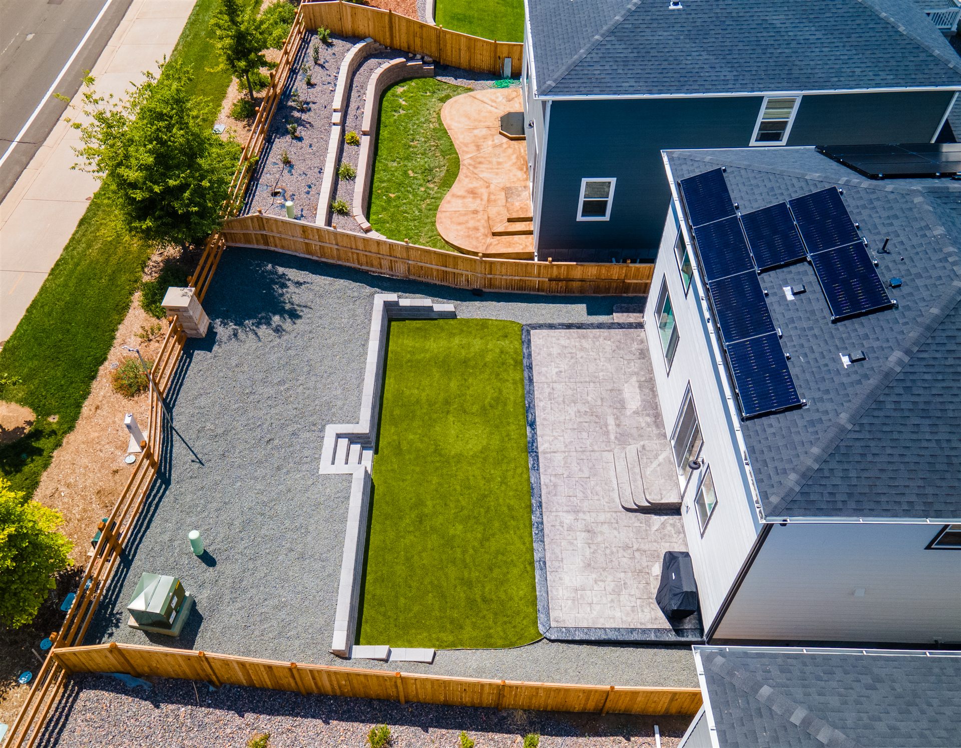 Aerial view of a Thornton backyard with turf, stamped patio and block walls