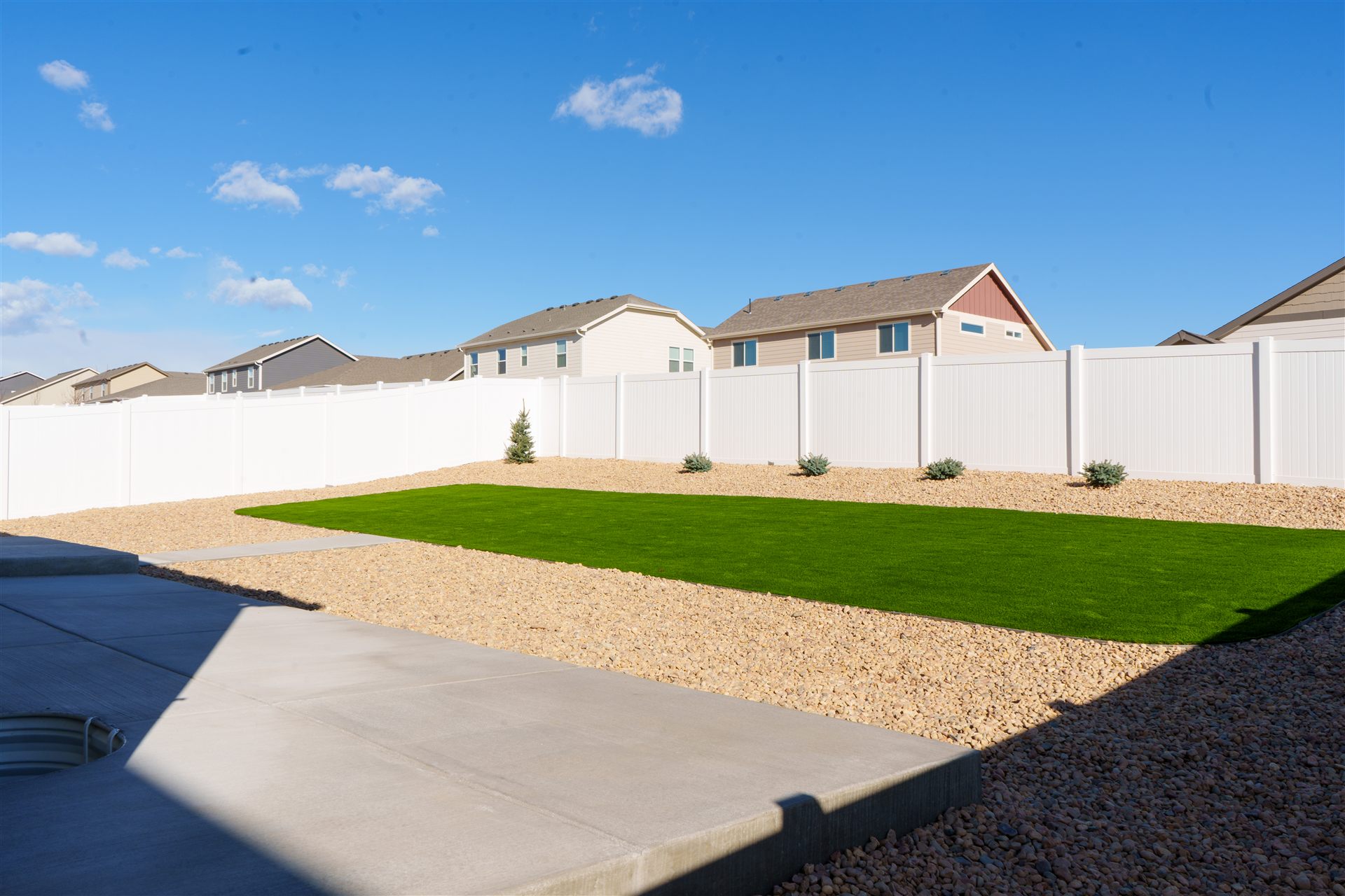 Concrete walk between rock beds and turf