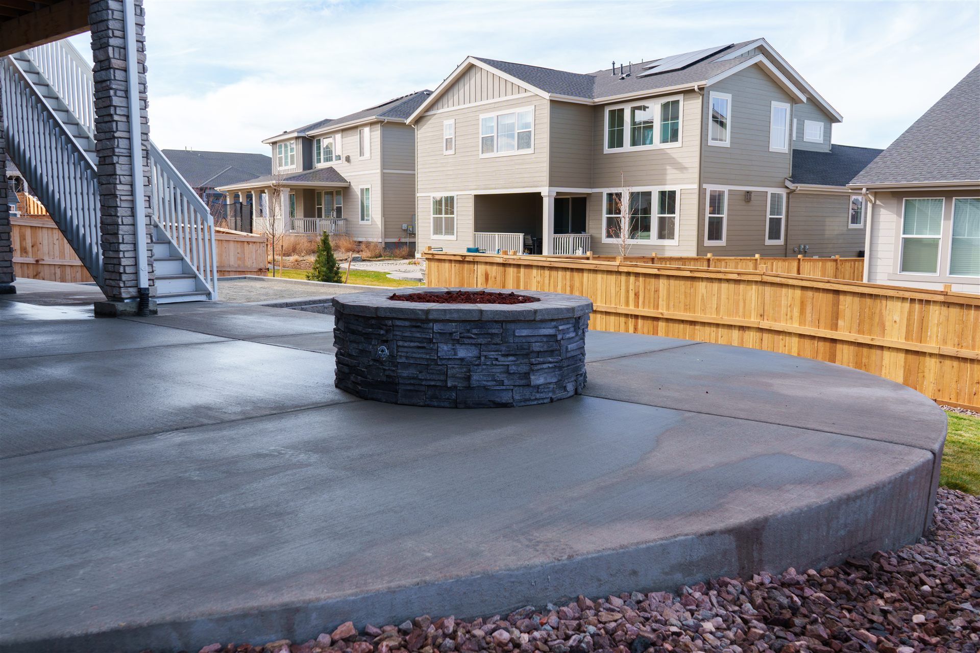 Curved concrete patio edge with a stone fire pit