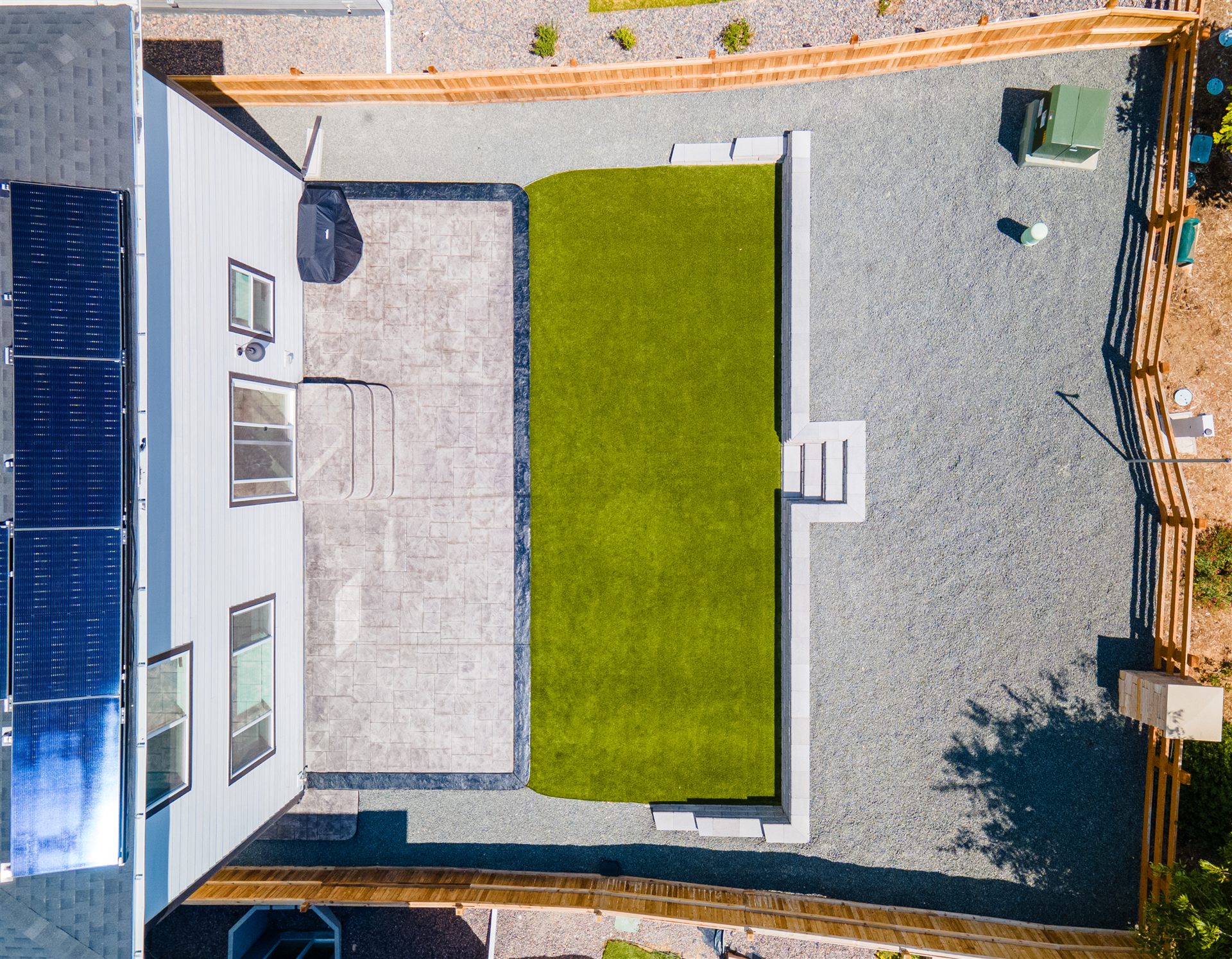 Overhead view of a stamped patio and rectangular turf lawn