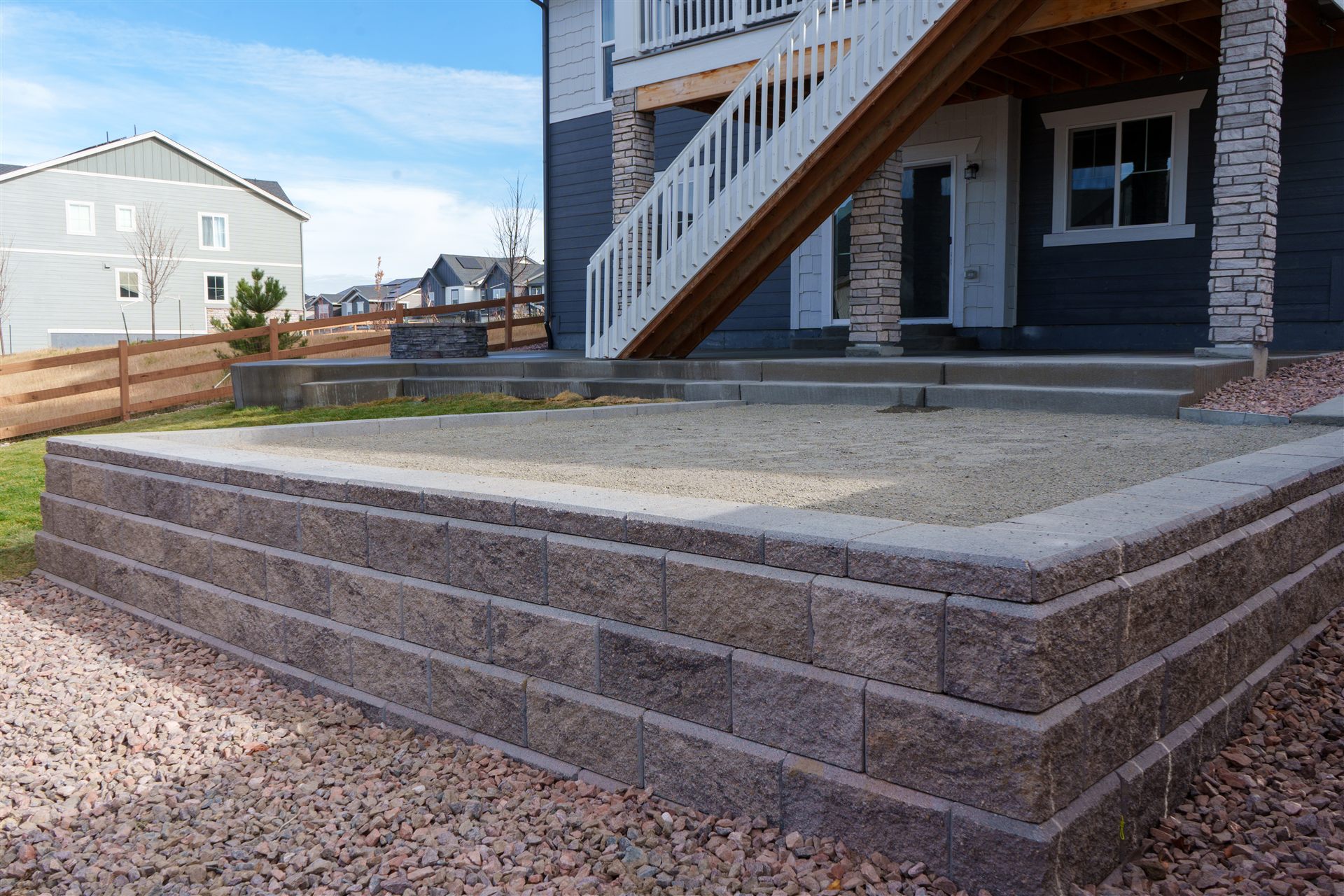 Raised block wall beside a patio and deck stairs