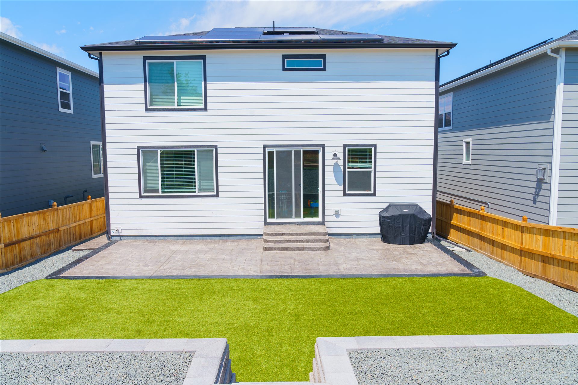 Stamped concrete patio and synthetic turf behind a new home in Thornton, CO