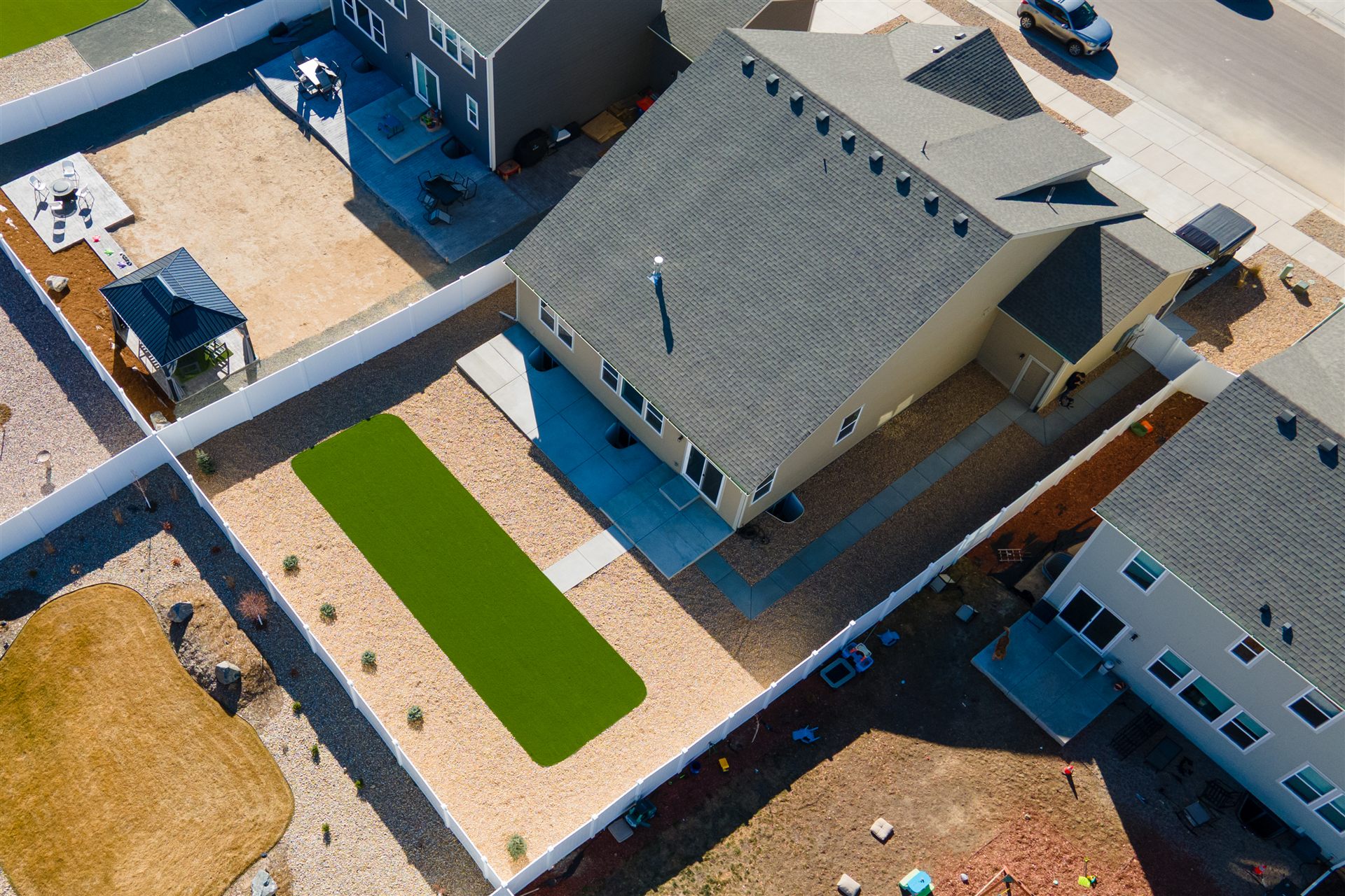Aerial view of a turf lawn inside a white vinyl fence